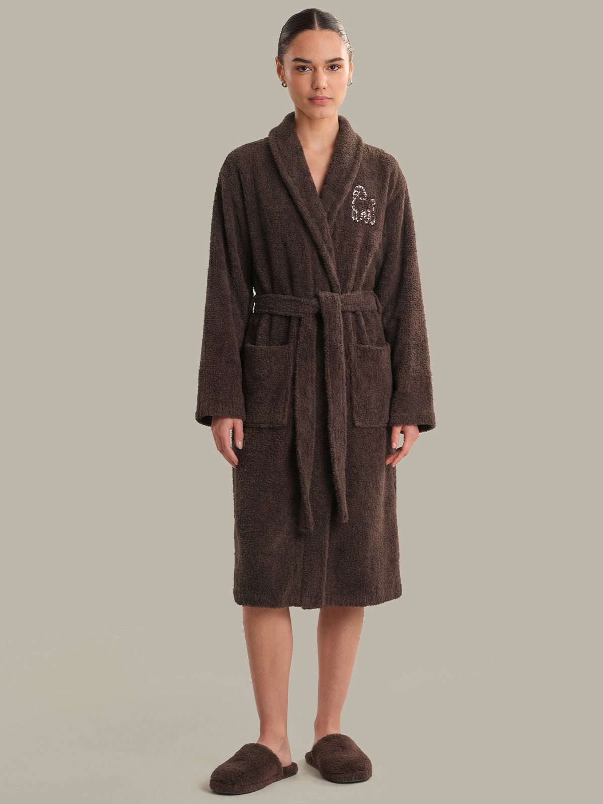 Woman wearing a brown robe with 'Sculpt' embroidery on a gray background