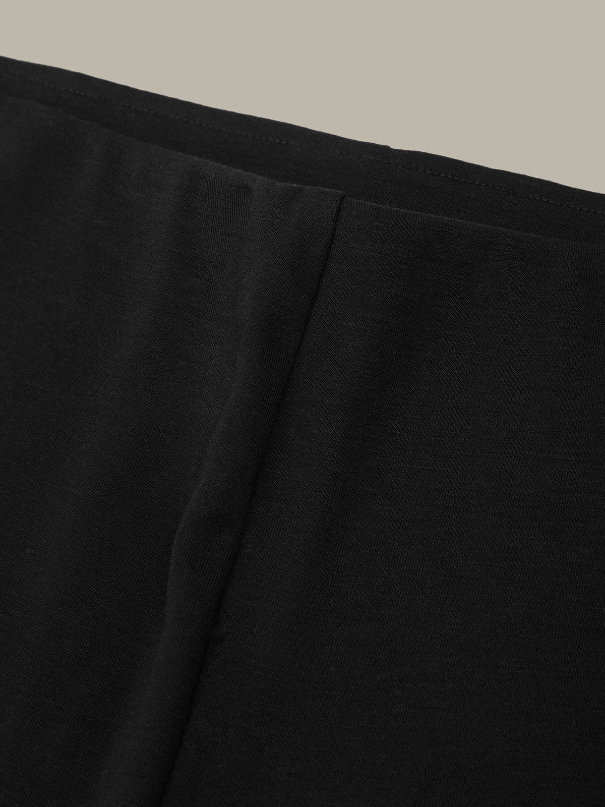 Close-up of black fabric texture on a beige background