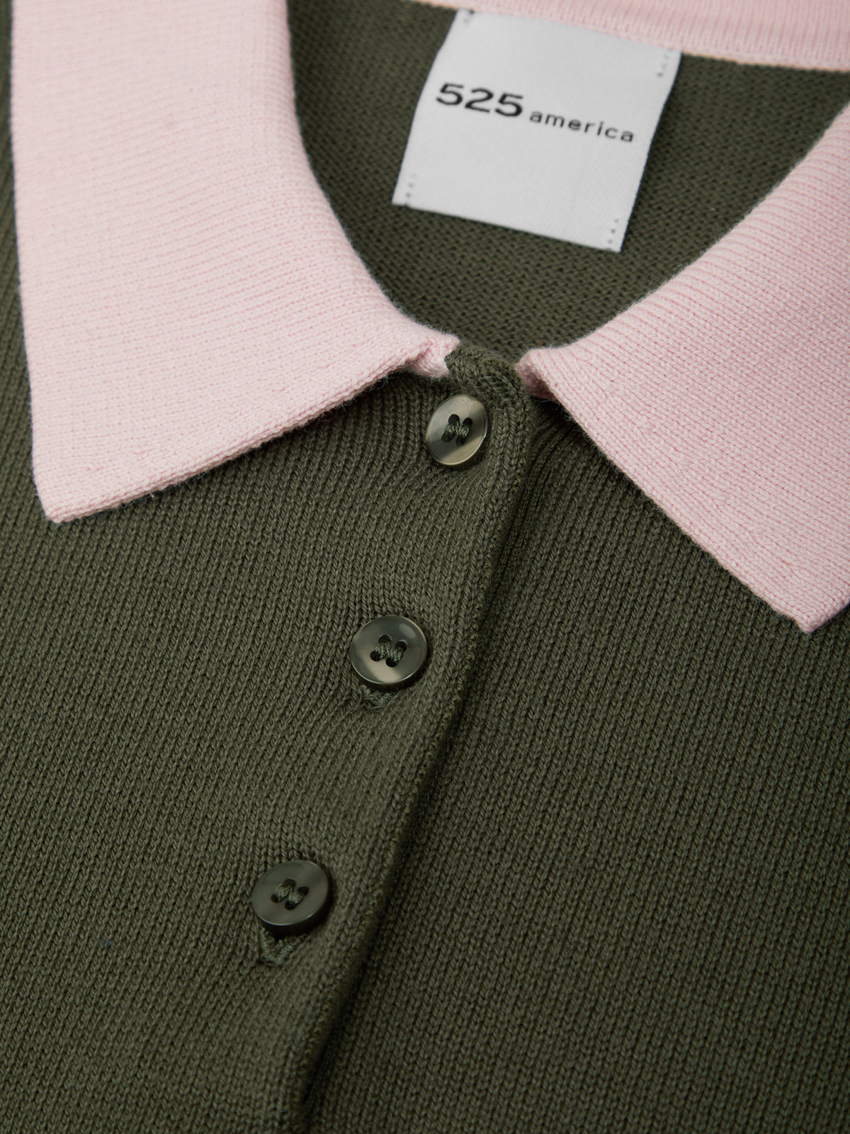 Green cardigan with pink collar and buttons, featuring a brand label.