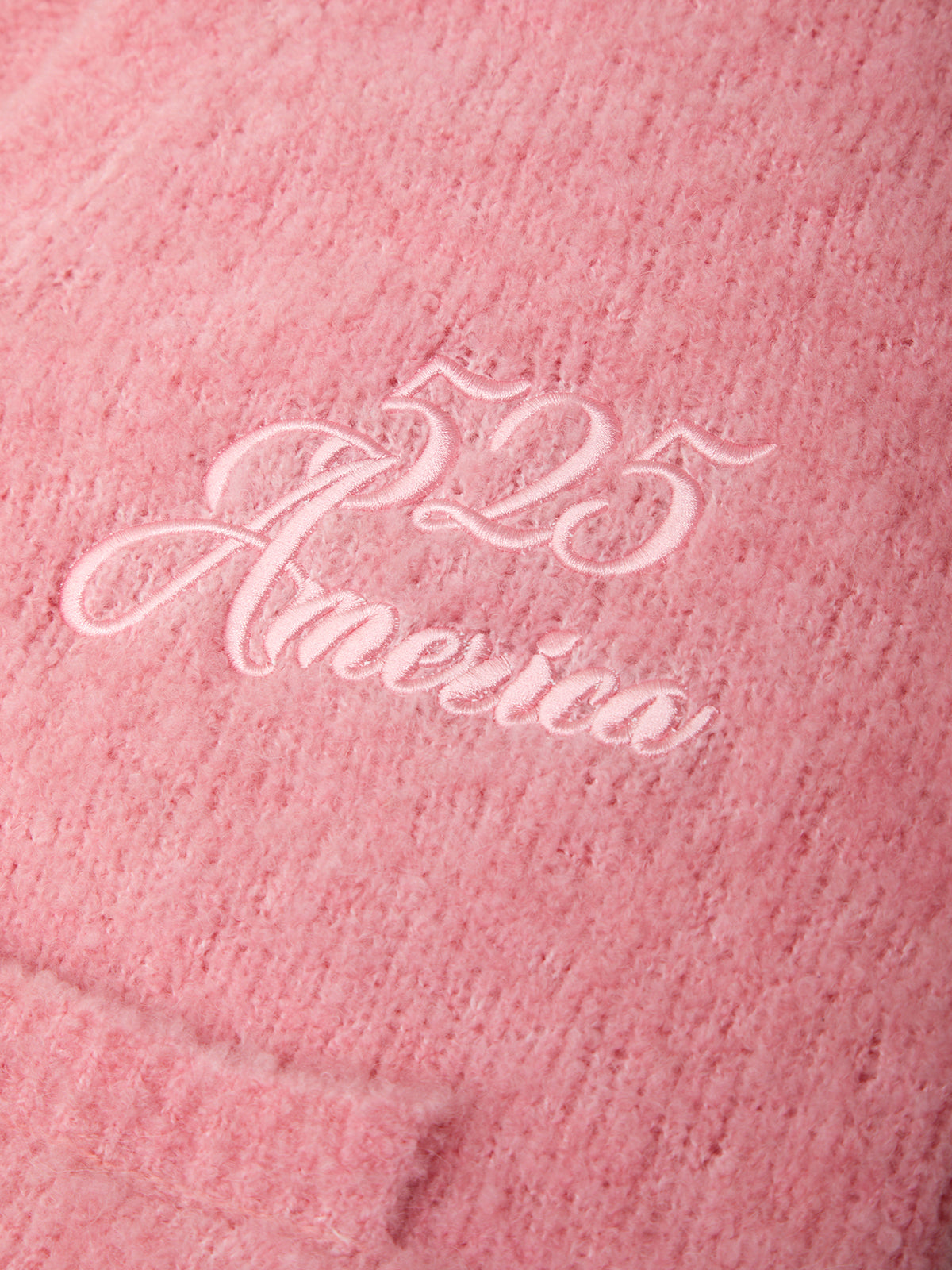 Pink fabric with '25 America' embroidered in white thread
