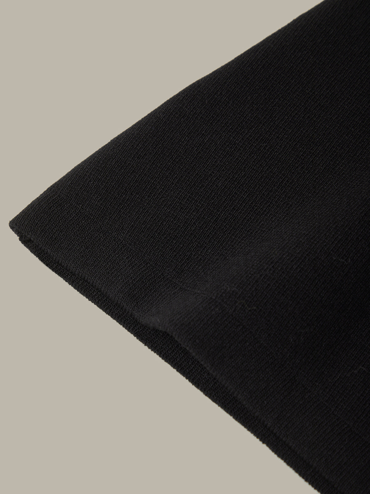 Close-up of a black fabric corner on a beige background