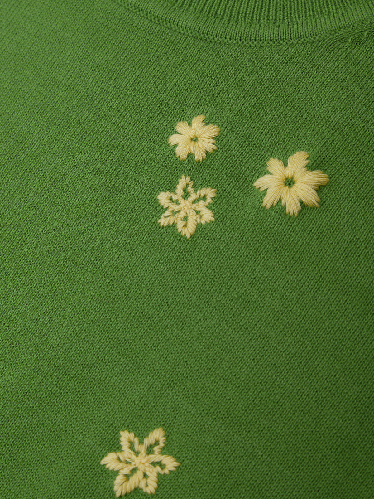 Green fabric with embroidered white flowers