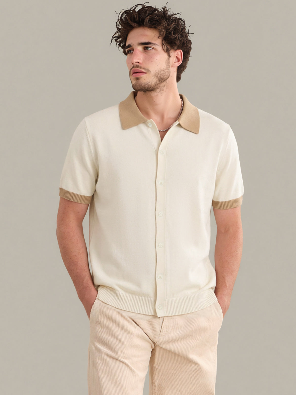 Man wearing a beige short-sleeve shirt with a collar against a neutral background