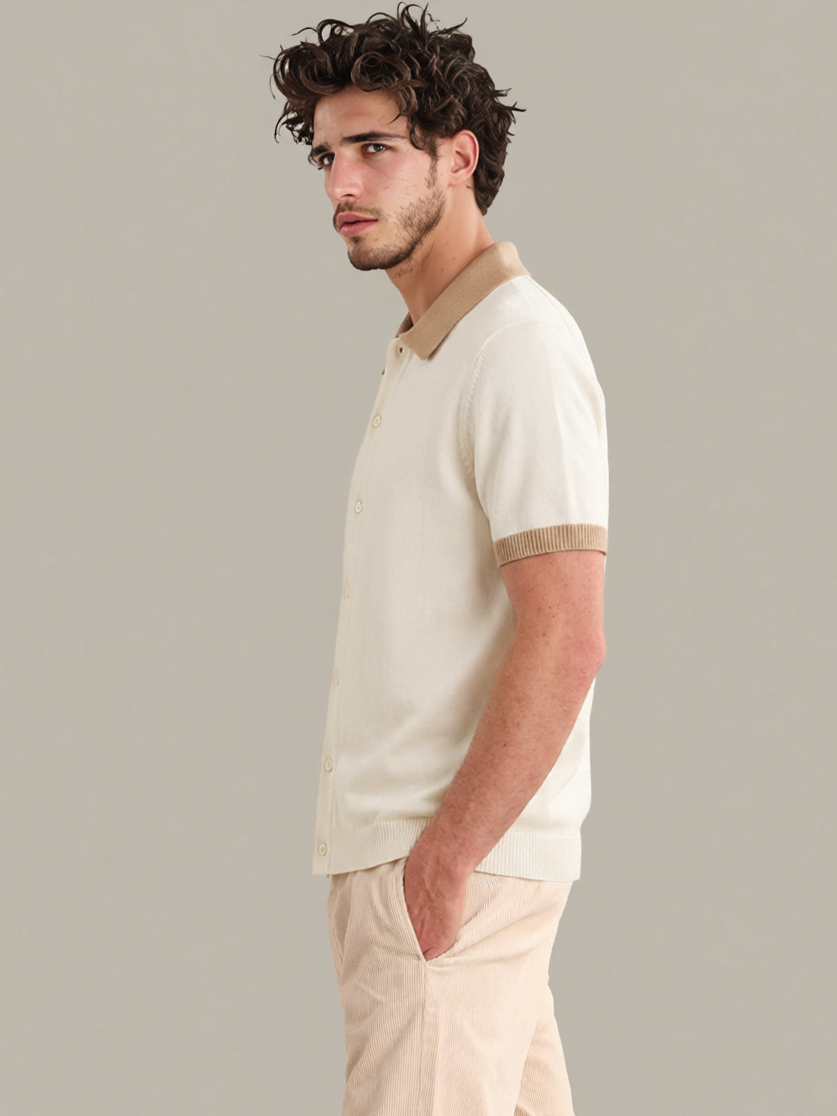 Man wearing a beige polo shirt and pants against a gray background