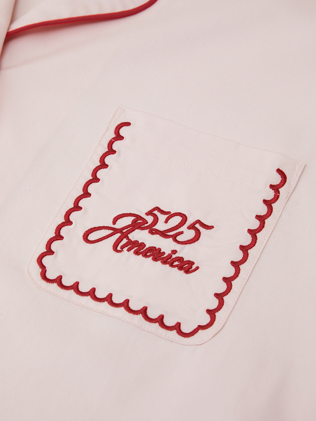 Embroidered design on a garment with red thread