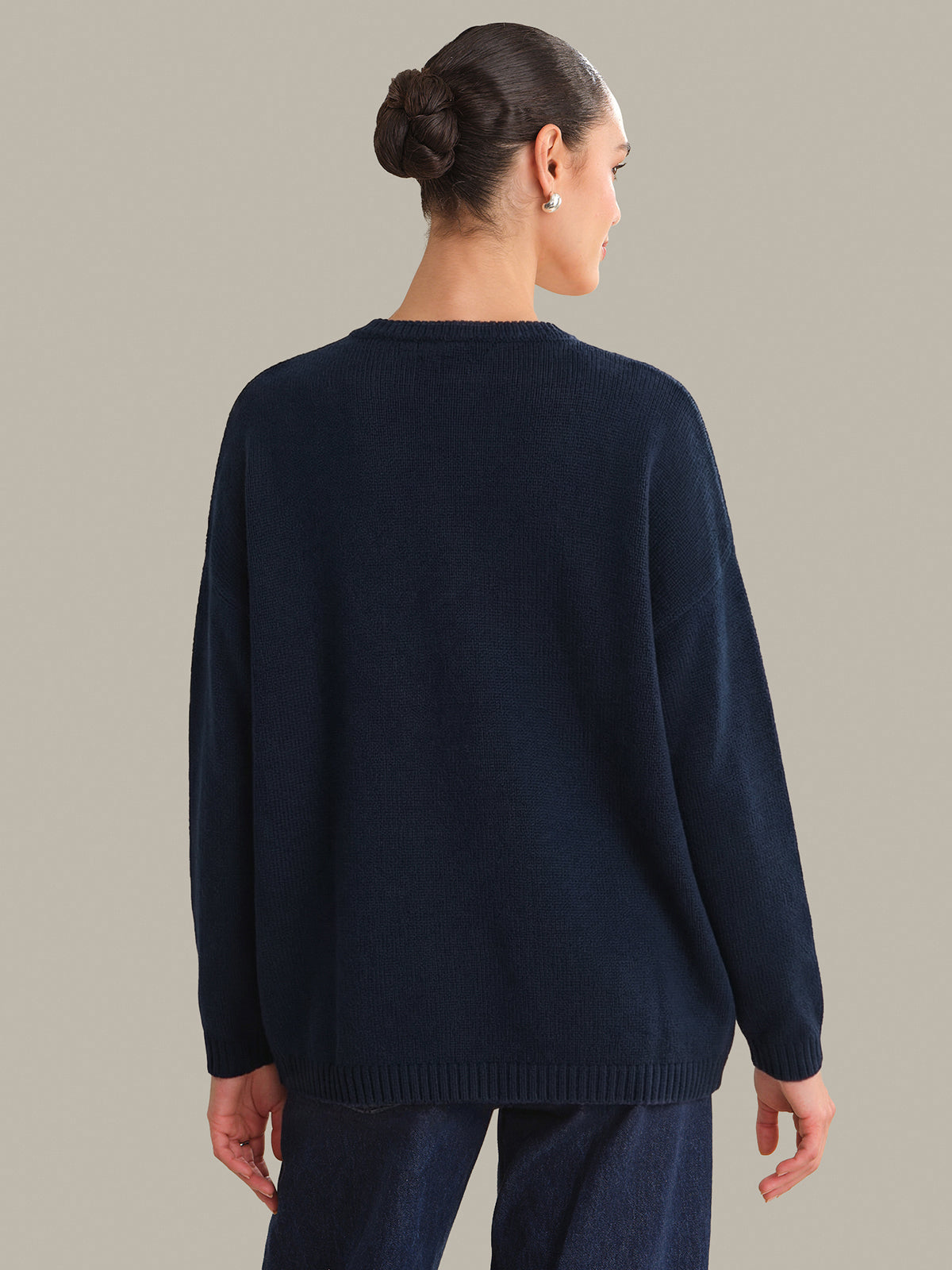 Person wearing a navy sweater against a neutral background