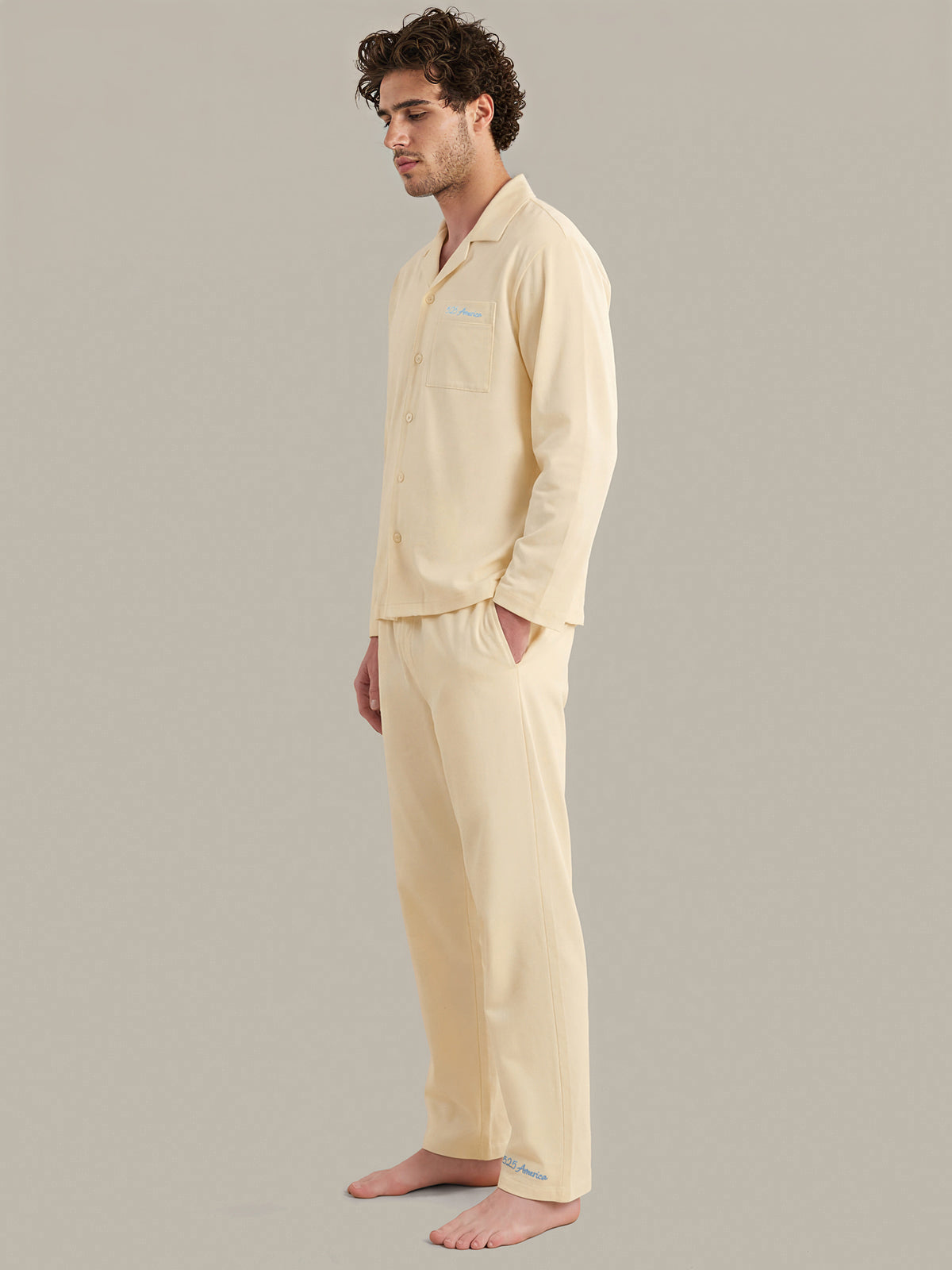 Man wearing a light yellow pajama set against a plain background