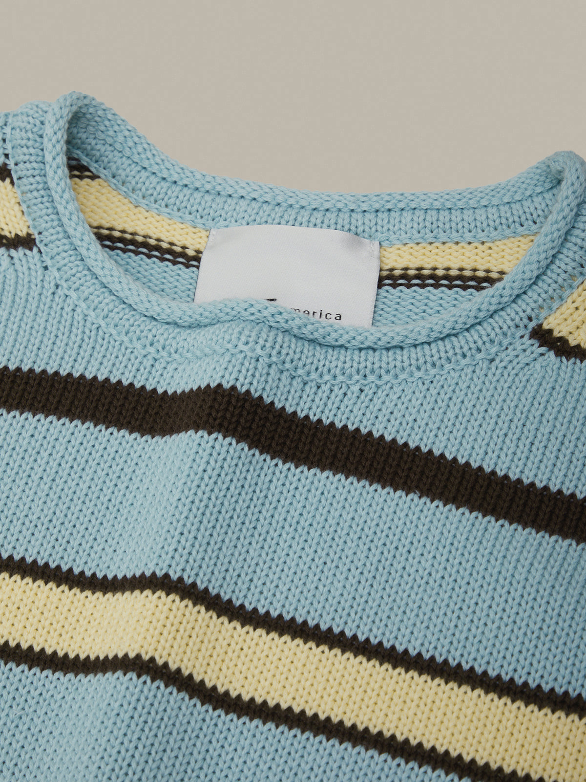 Close-up of a knitted sweater with horizontal stripes on a neutral background