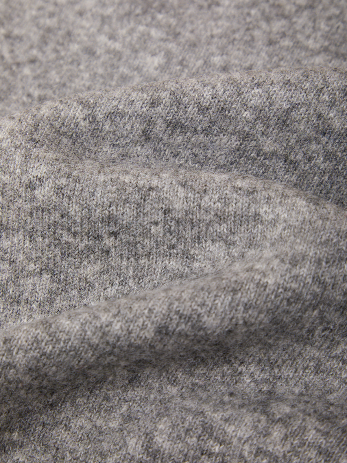 Close-up of a heather gray knit fabric with soft folds showing the texture and weave.