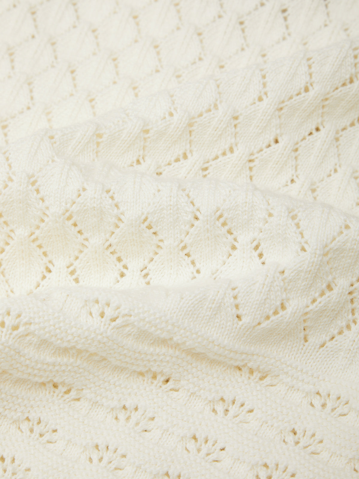 Close-up of a textured white fabric with a diamond pattern