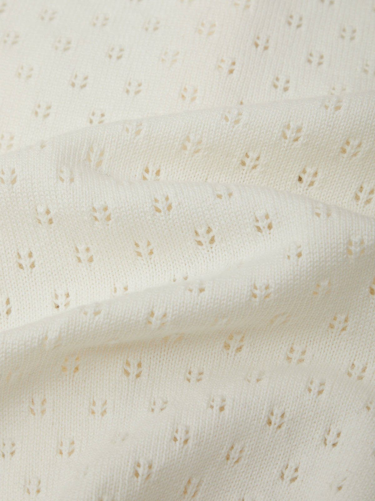 Close-up of a textured white fabric with small patterns