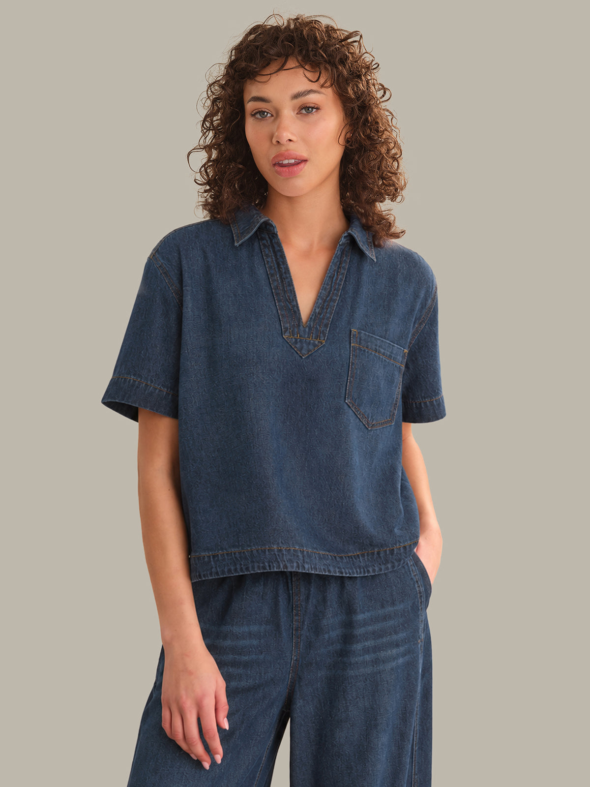 Woman wearing a denim outfit on a plain background