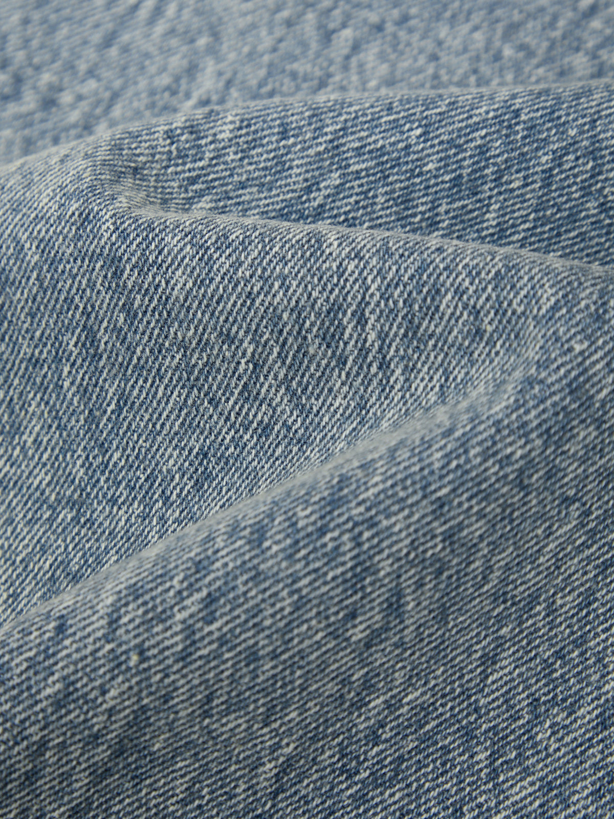 Close-up of blue denim fabric with a subtle pattern