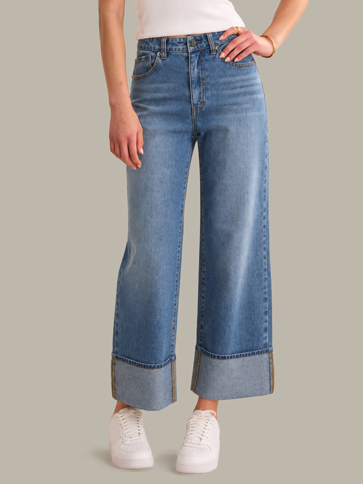 Person wearing blue wide-leg jeans on a gray background