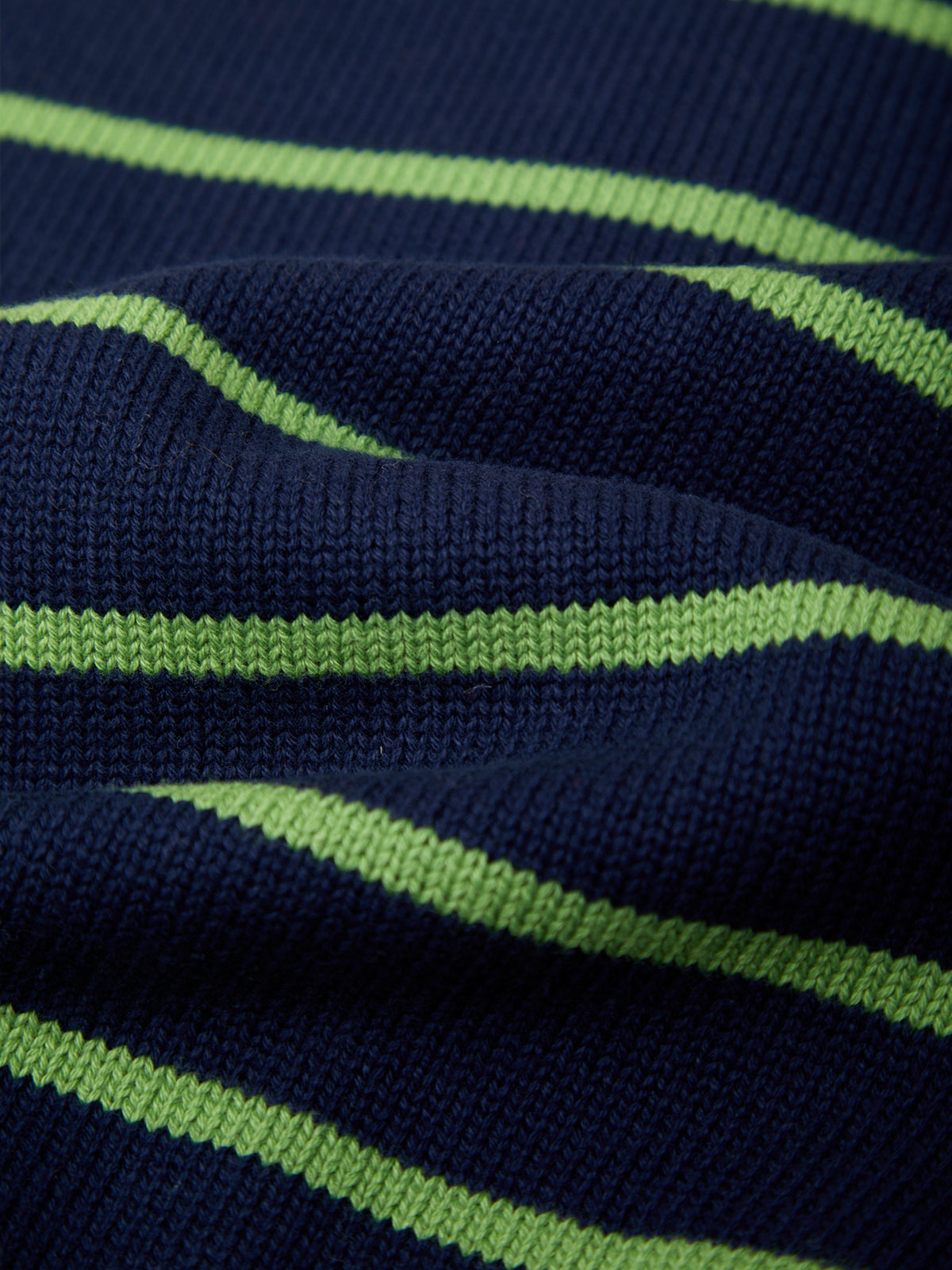 Close-up of a ribbed knit fabric with horizontal lime green stripes on a dark navy blue background.