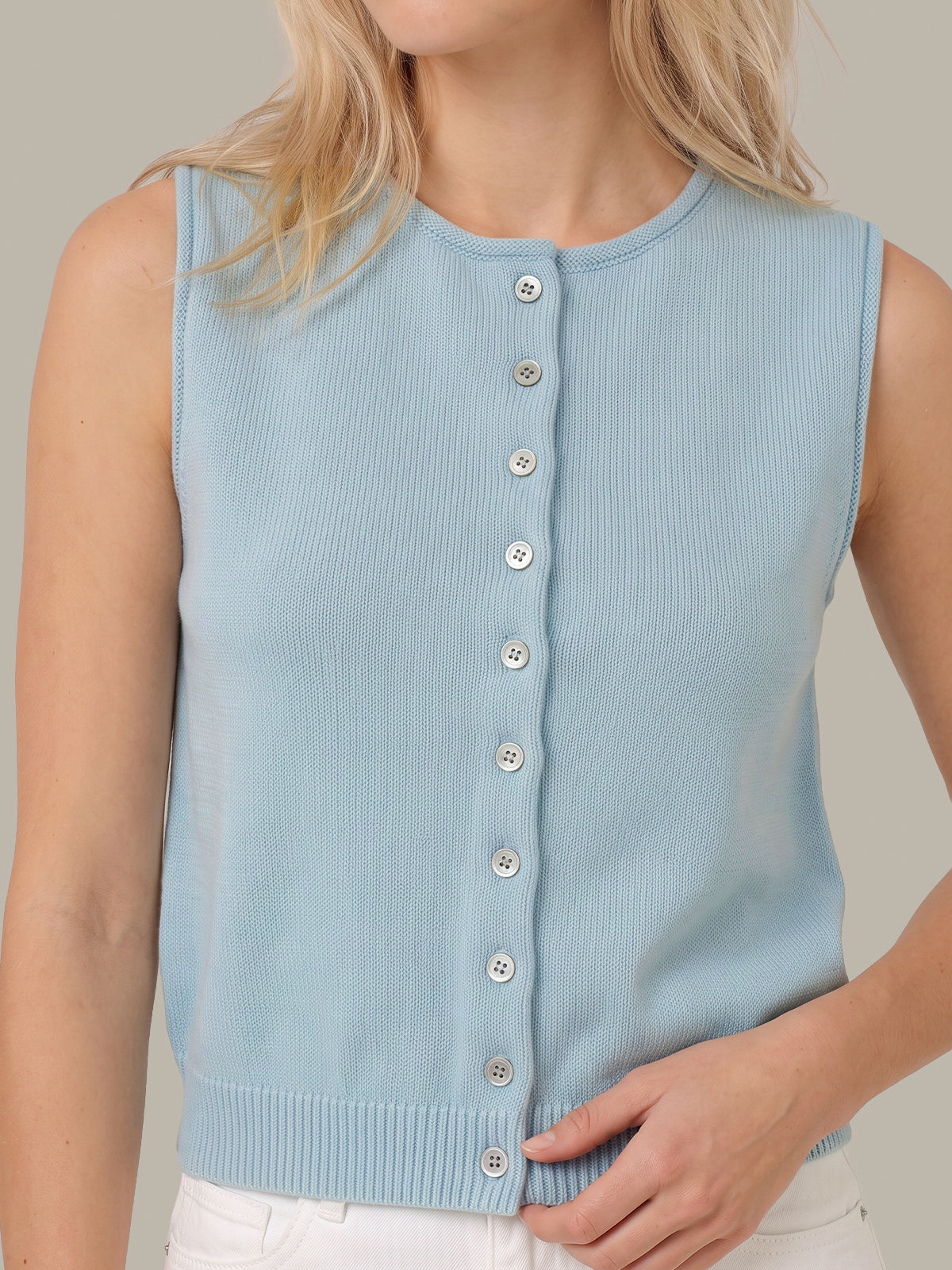 A sleeveless light blue ribbed knit vest with a front button closure, worn by a model against a plain beige background.
