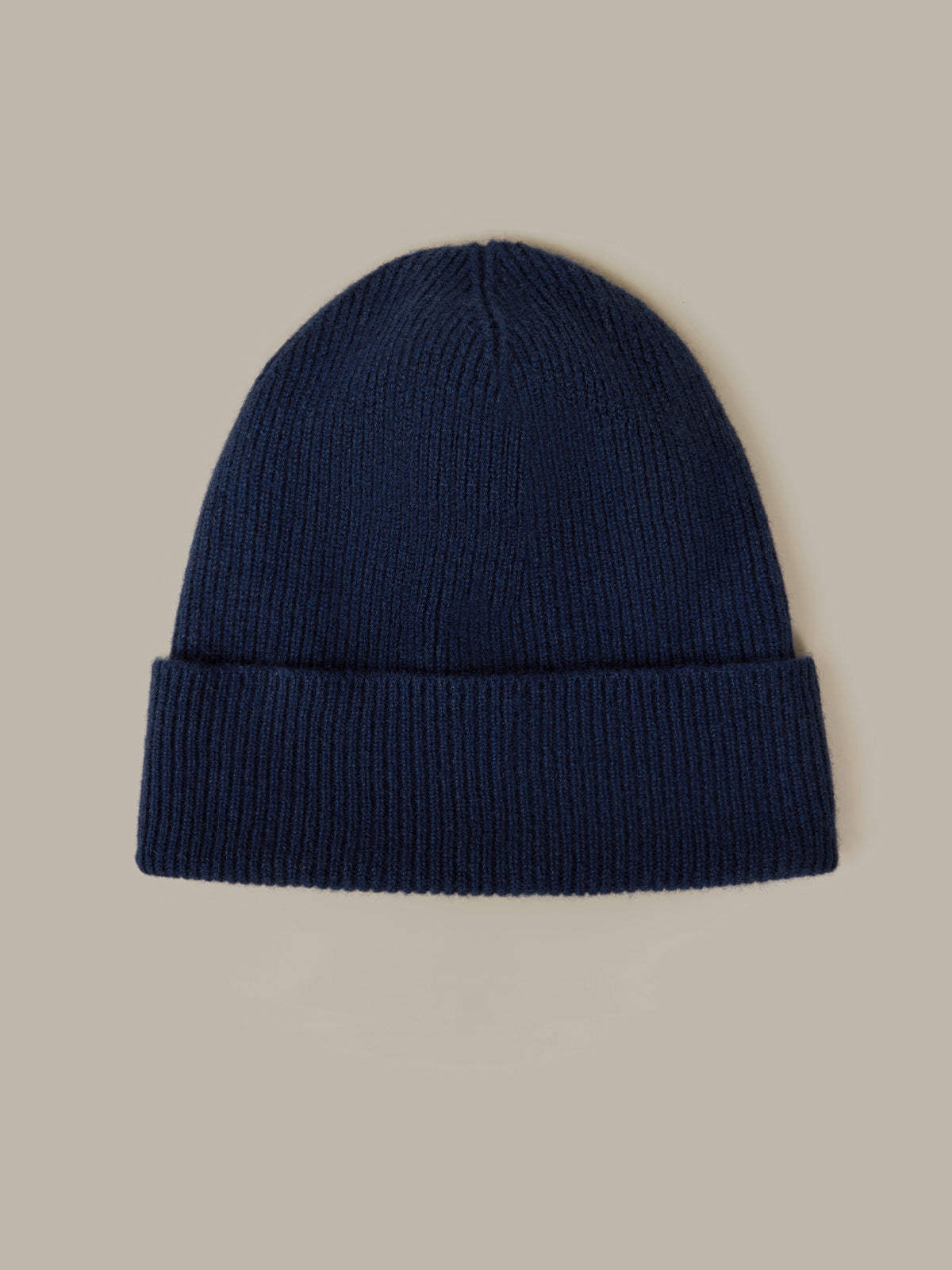 Navy blue beanie on a beige background
