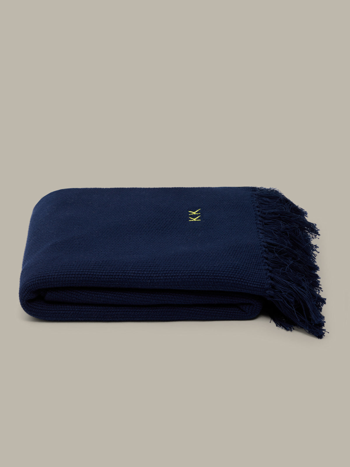 Navy blue blanket with a logo on a beige background