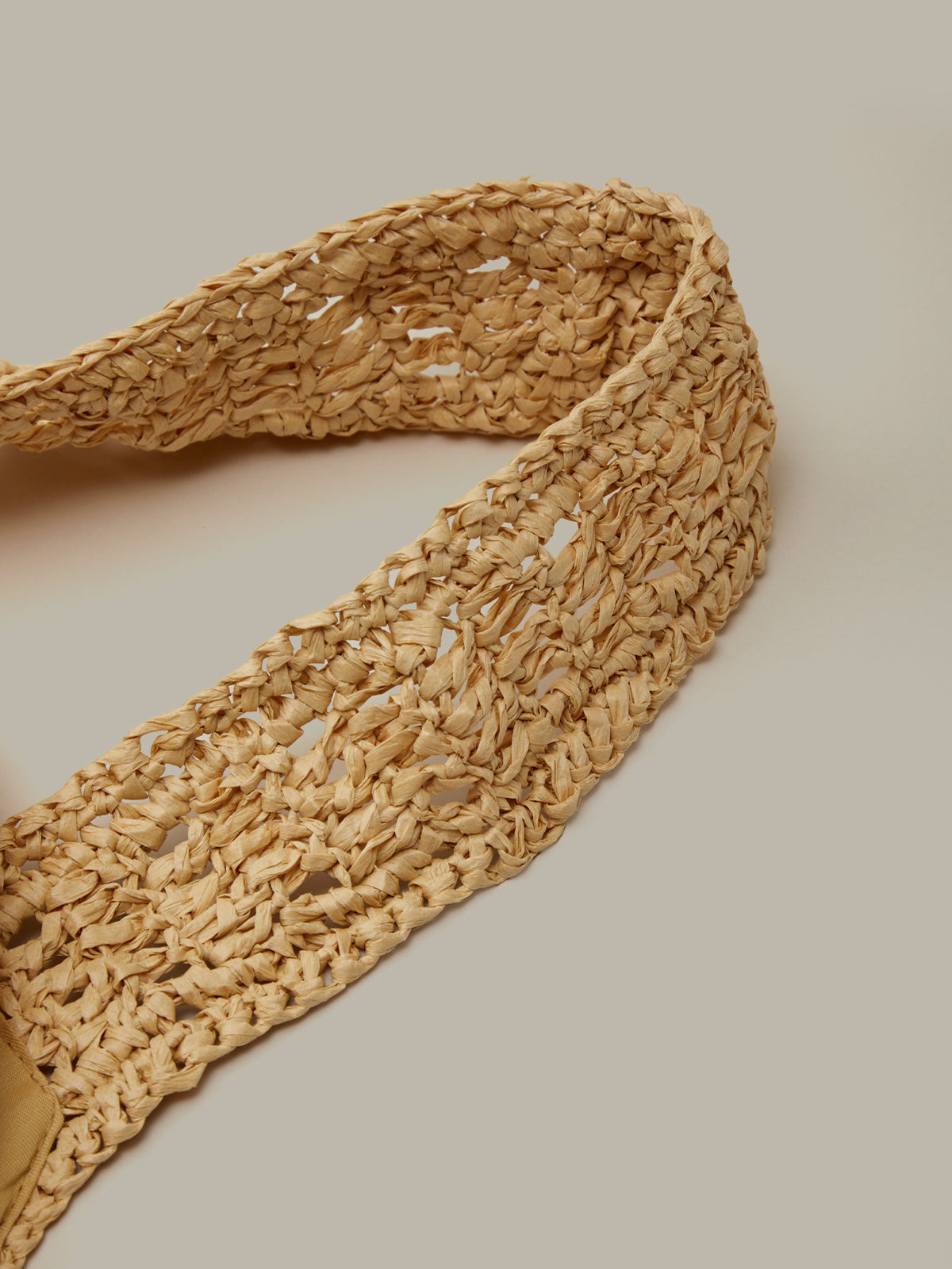 Woven straw belt on a beige background