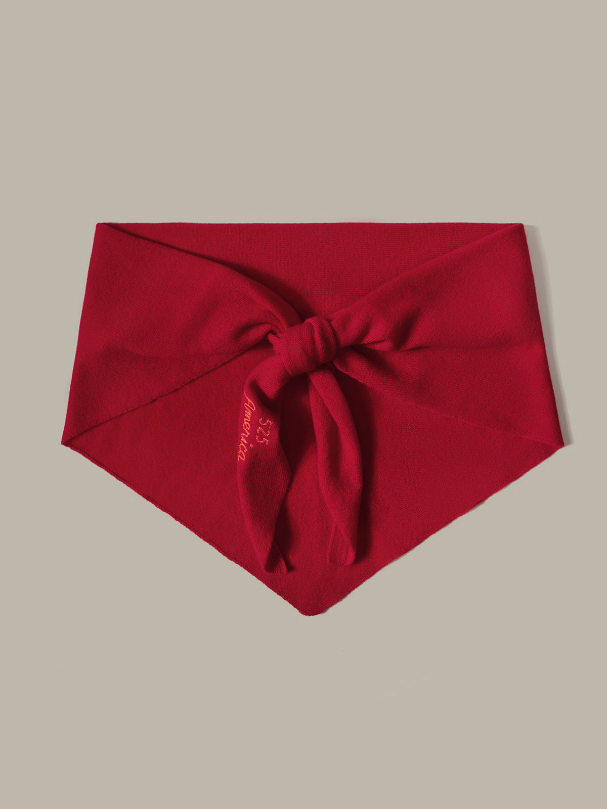 Red headband with a bow on a beige background