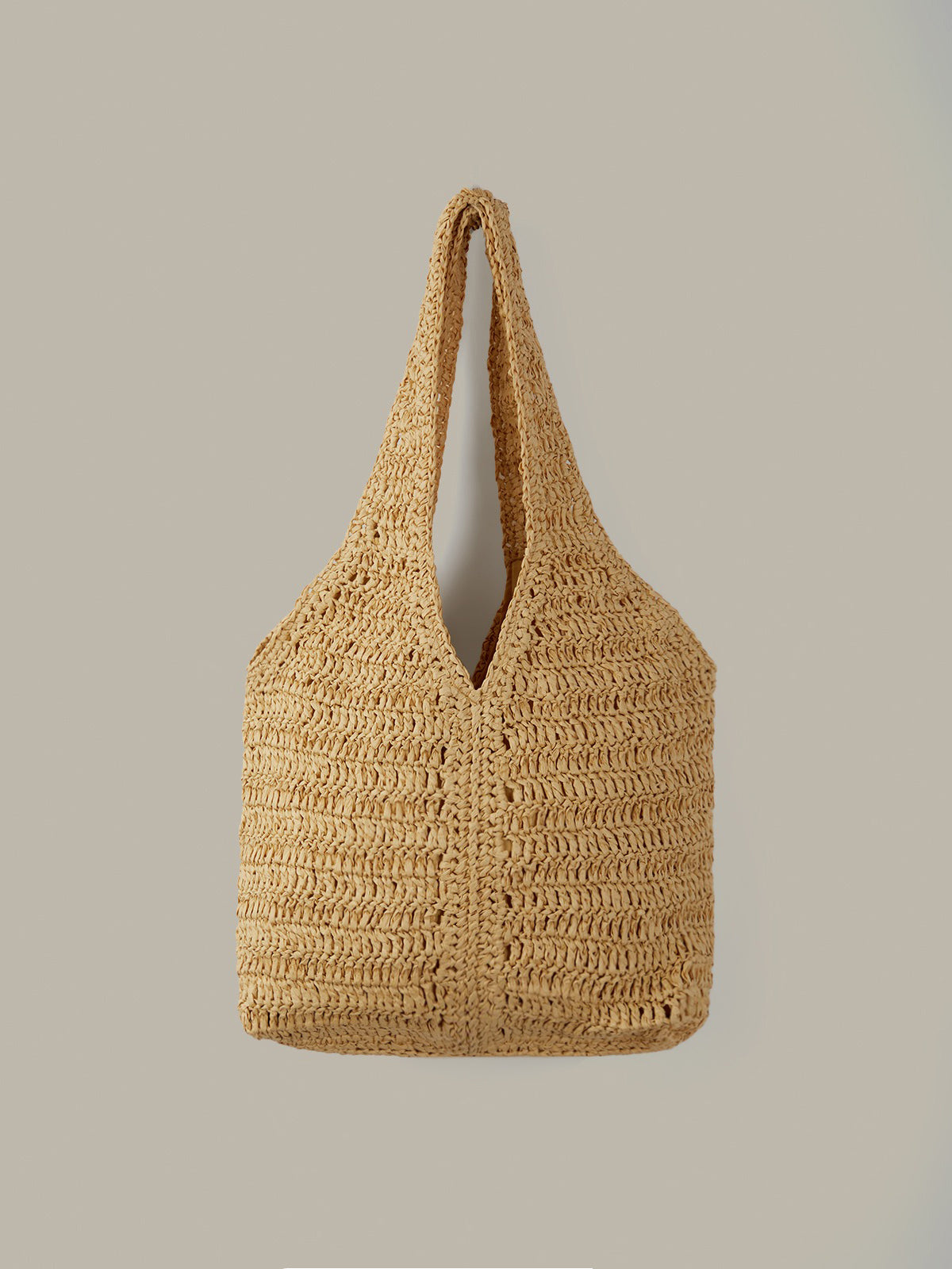 Woven straw bag on a plain background