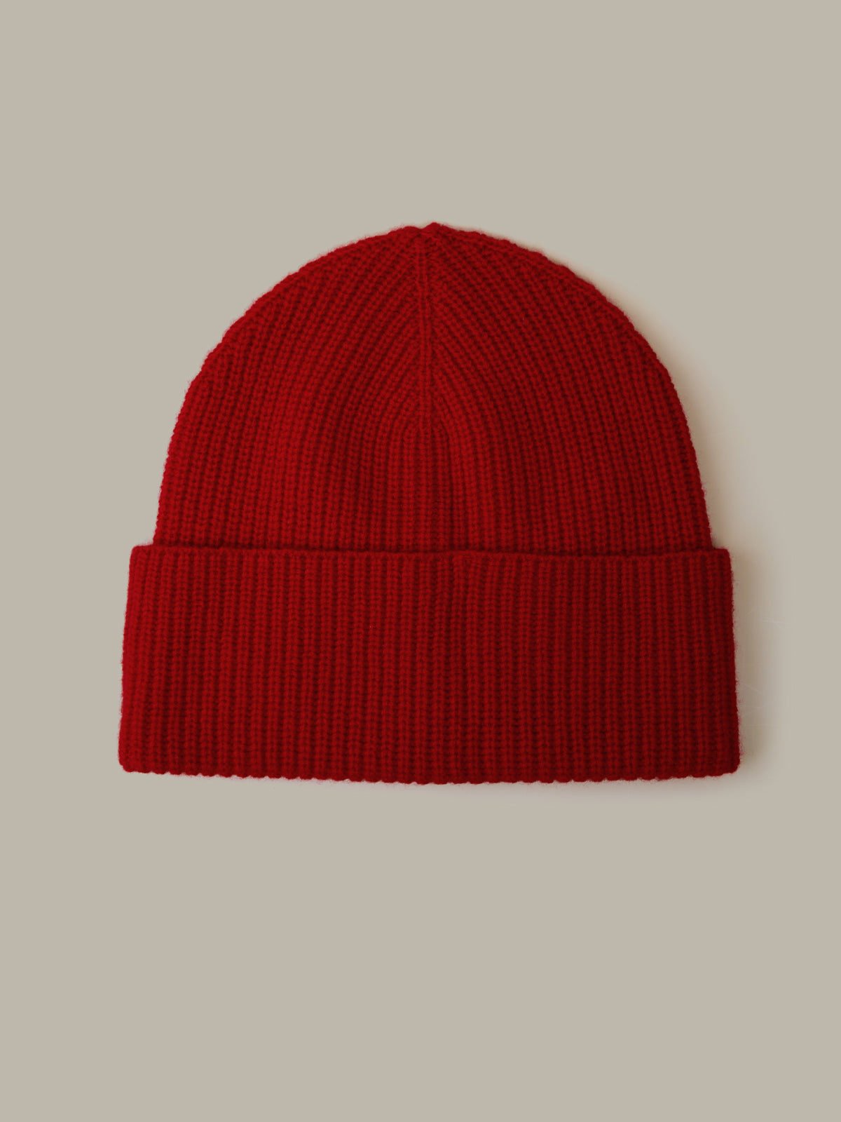 Red knit beanie on a beige background