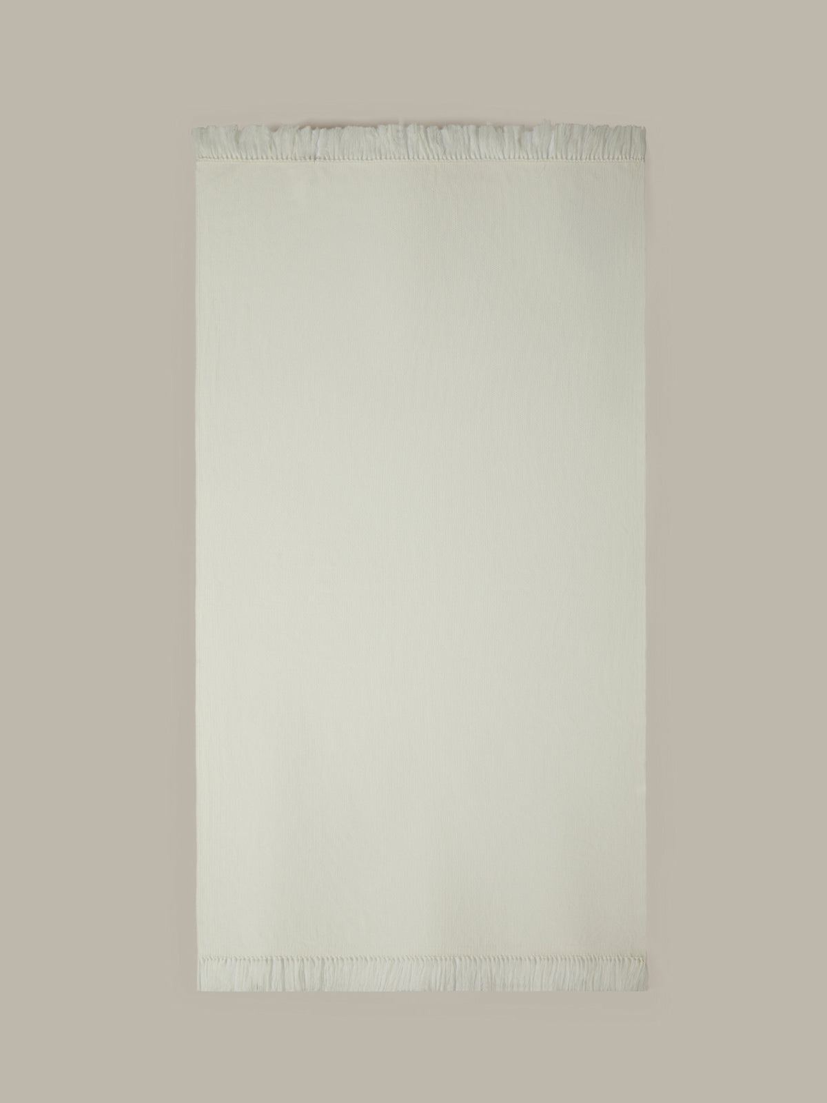 Light green rug with fringe on a beige background