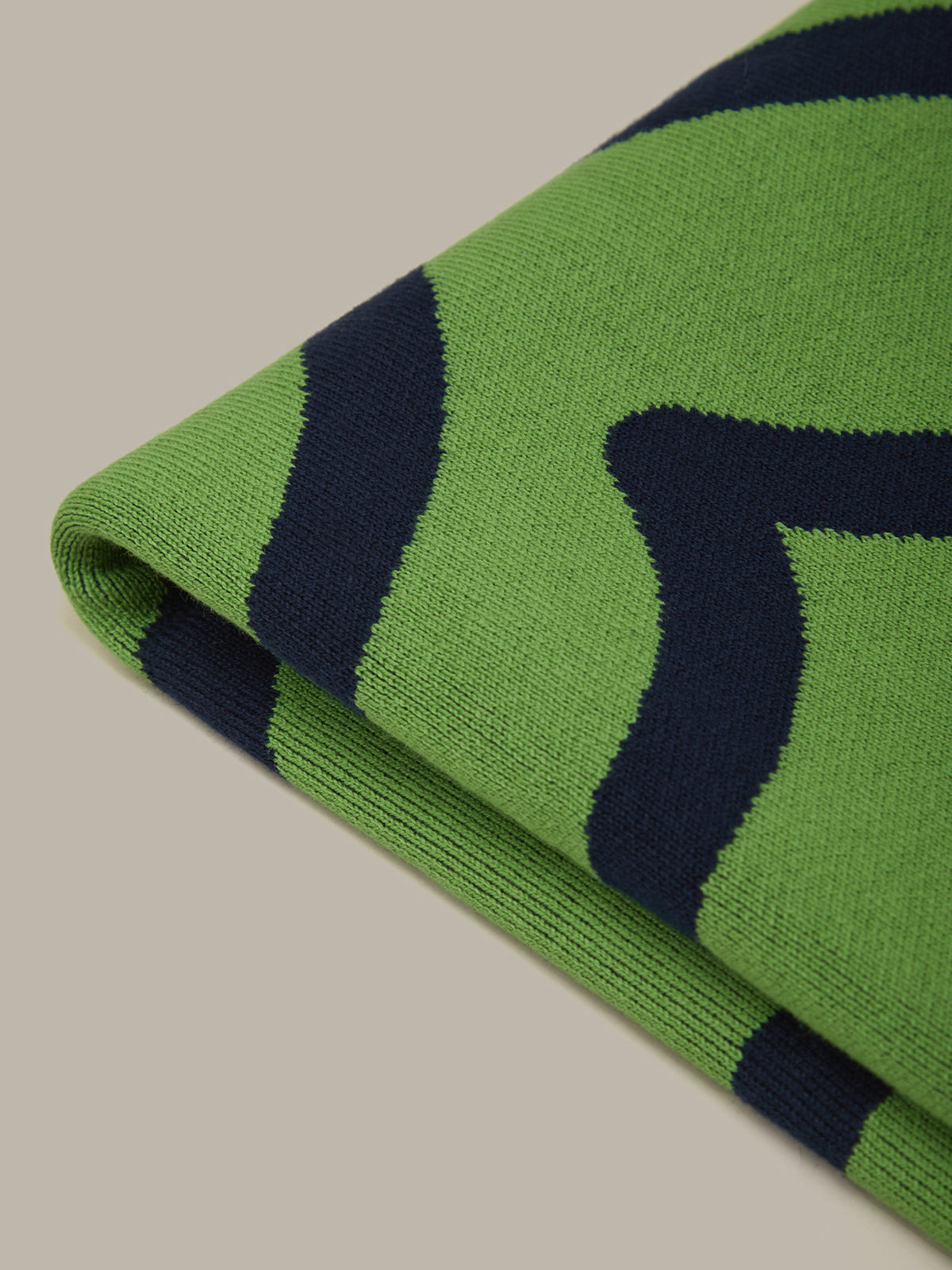Green and navy striped fabric on a beige background