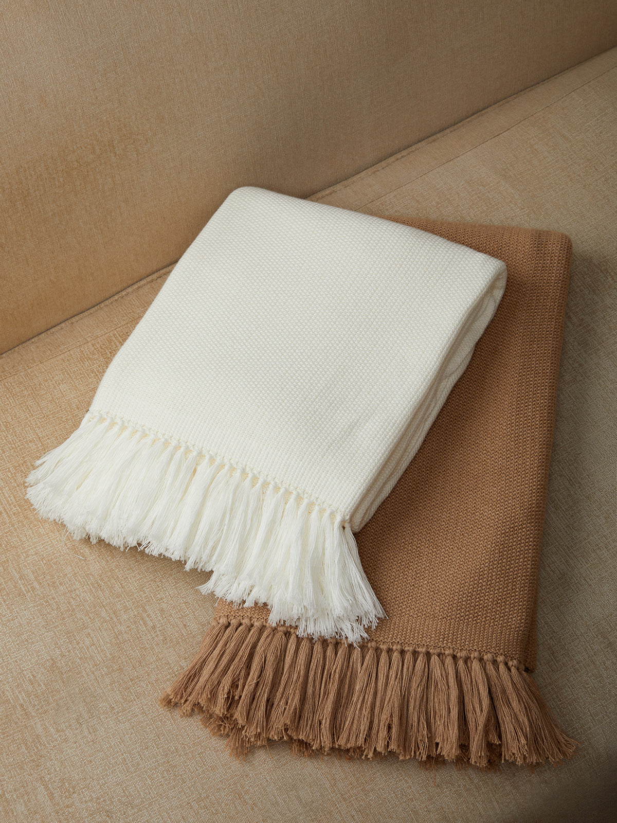 White and brown textured throw blankets on a neutral background