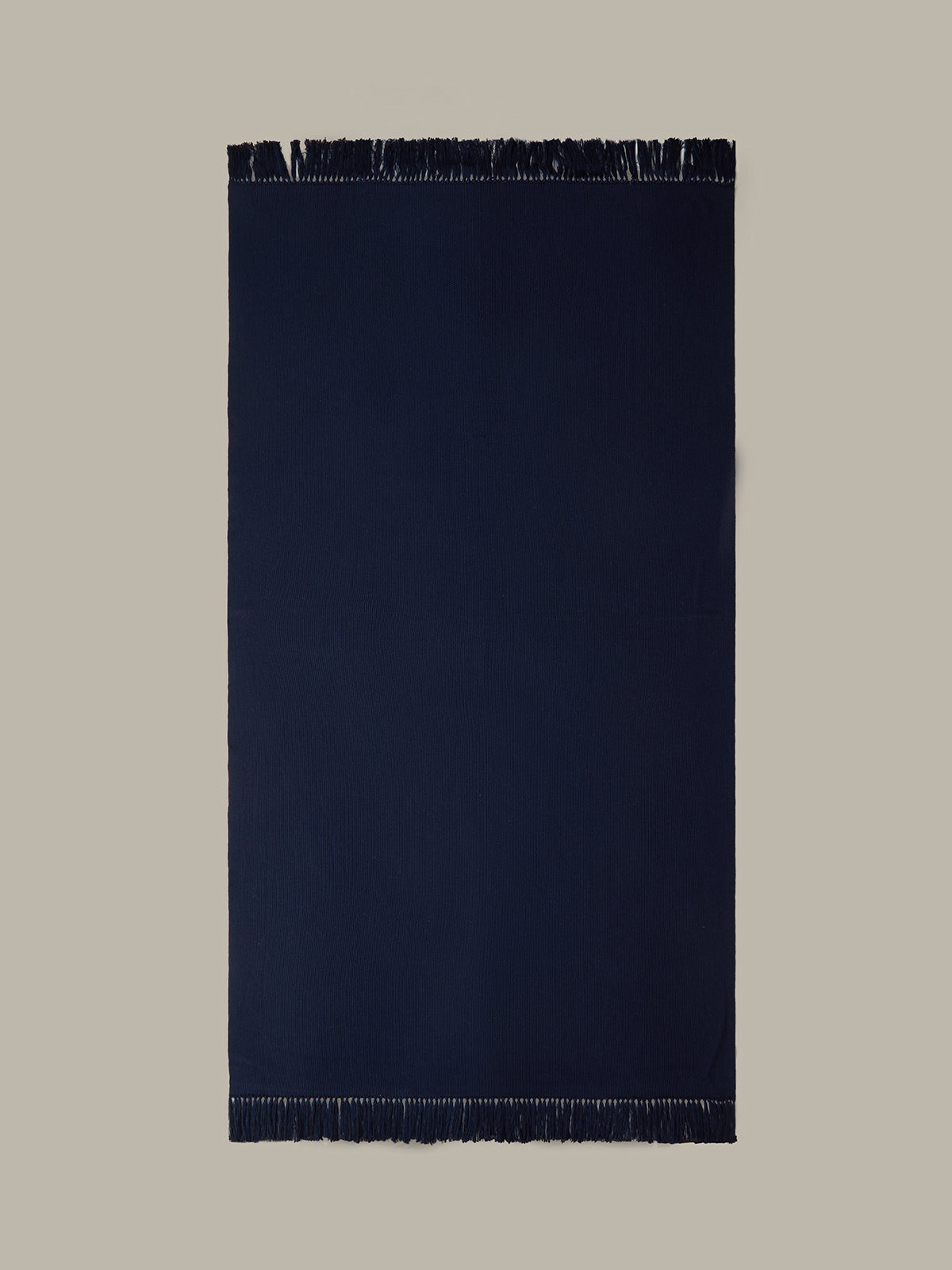 Navy blue rug with fringes on a beige background