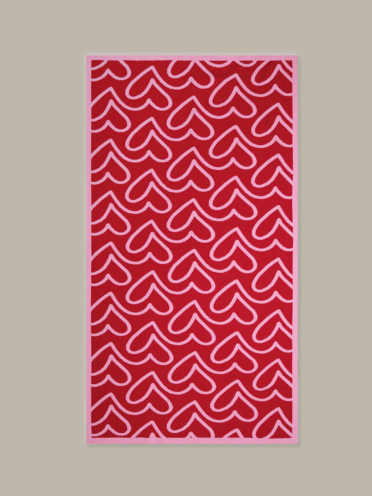 Red towel with white heart pattern on a beige background
