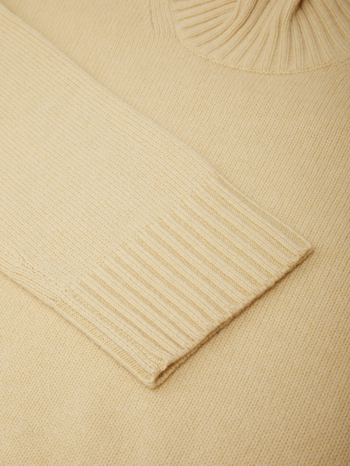 Close-up of a beige sweater with ribbed texture