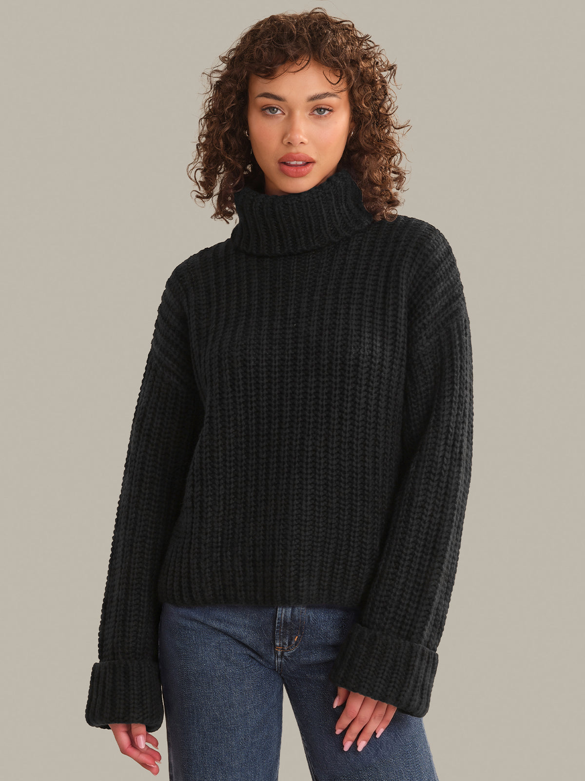 Woman wearing a black turtleneck sweater against a neutral background