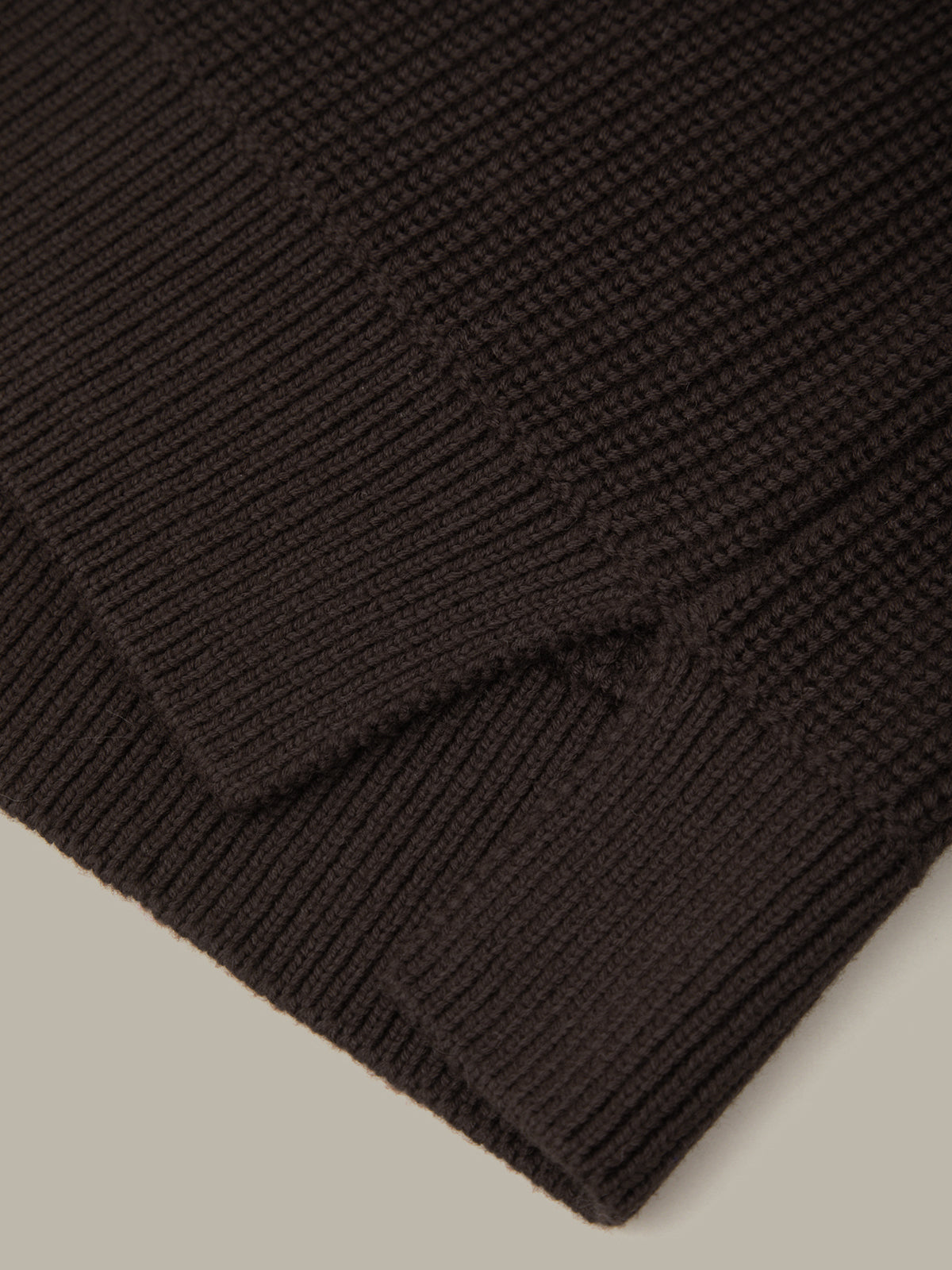 Dark brown knitted fabric on a beige background