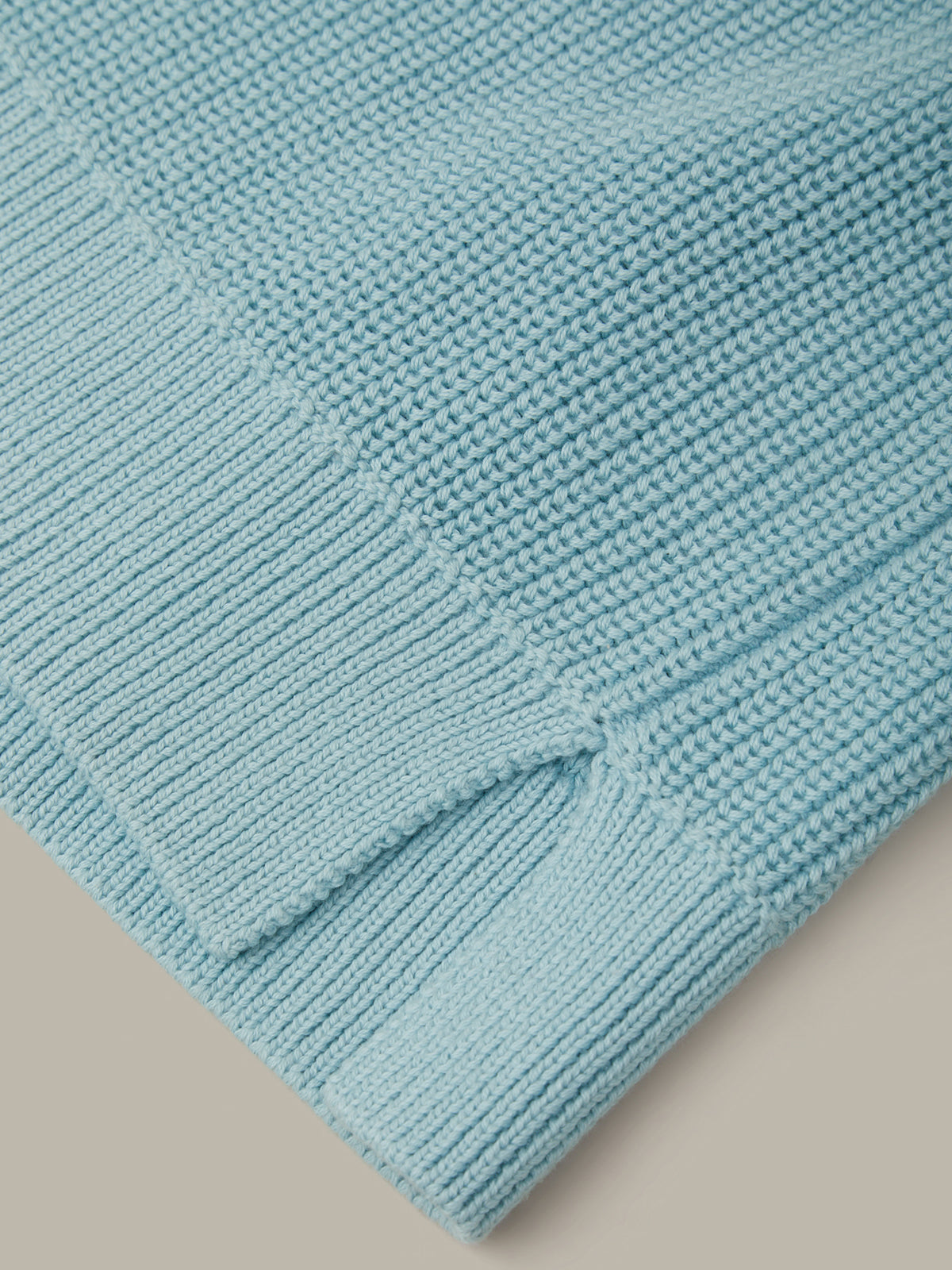 Close-up of a textured blue fabric on a neutral background