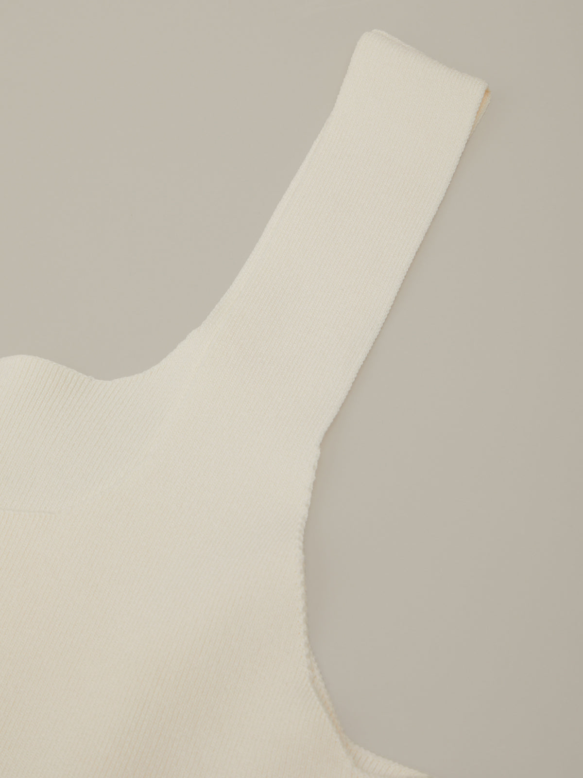 Close-up of a beige tank with a V-neckline on a neutral background