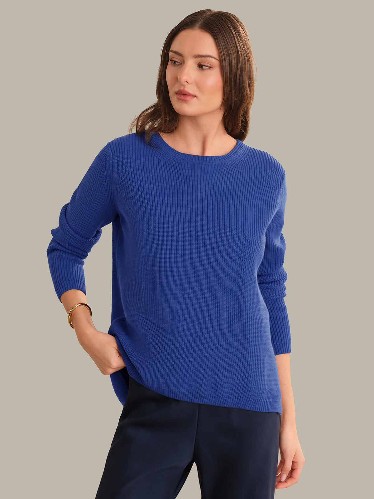 Woman wearing a blue sweater against a gray background