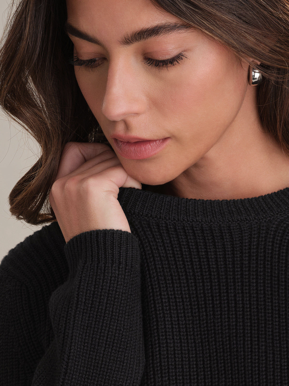Woman wearing a black sweater with a neutral background
