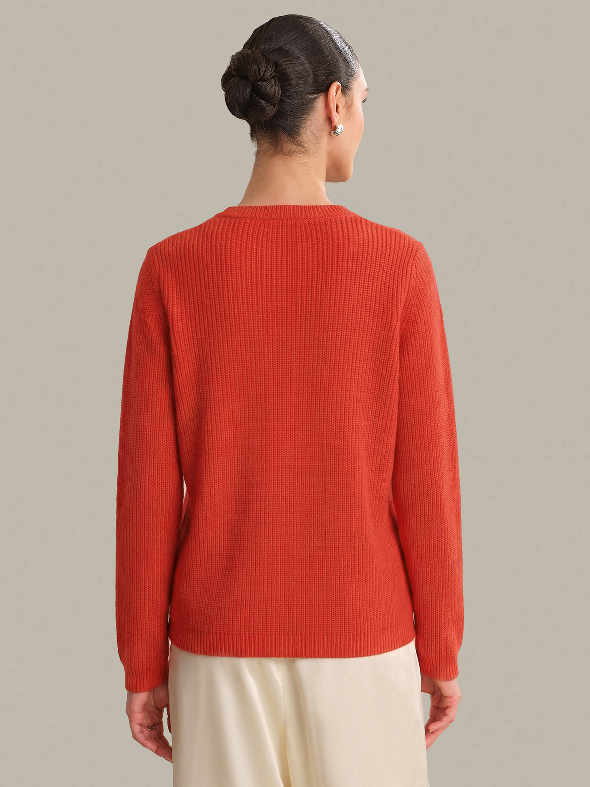 Person wearing a red sweater on a beige background