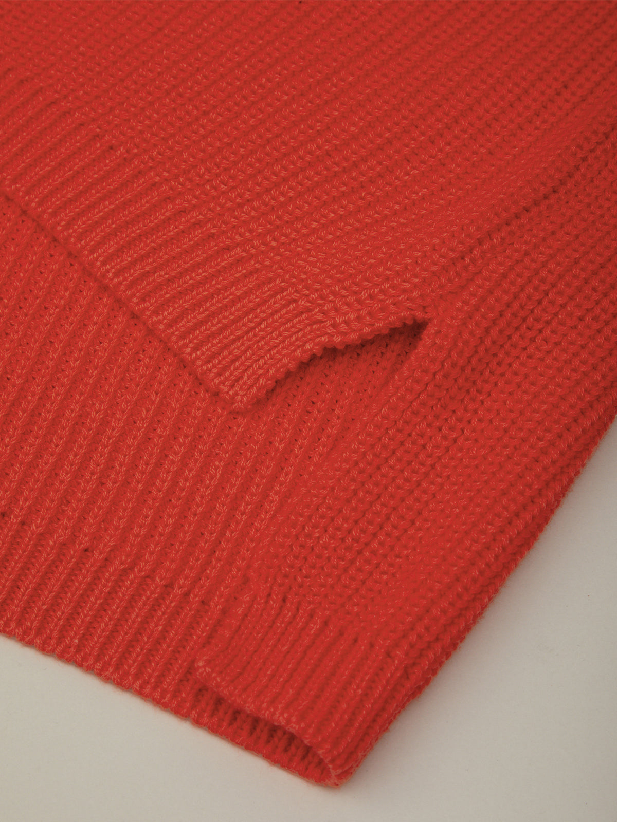 Close-up of a red knitted fabric on a light gray background