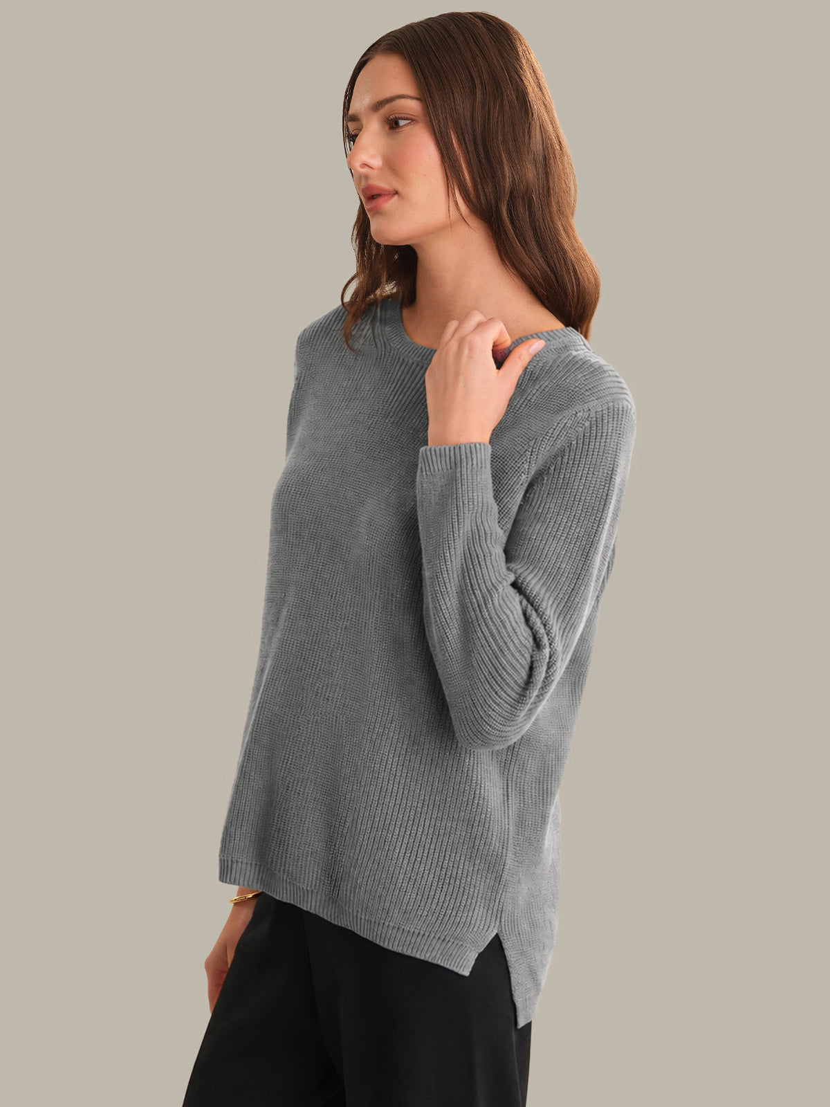 Woman wearing a gray sweater against a plain background
