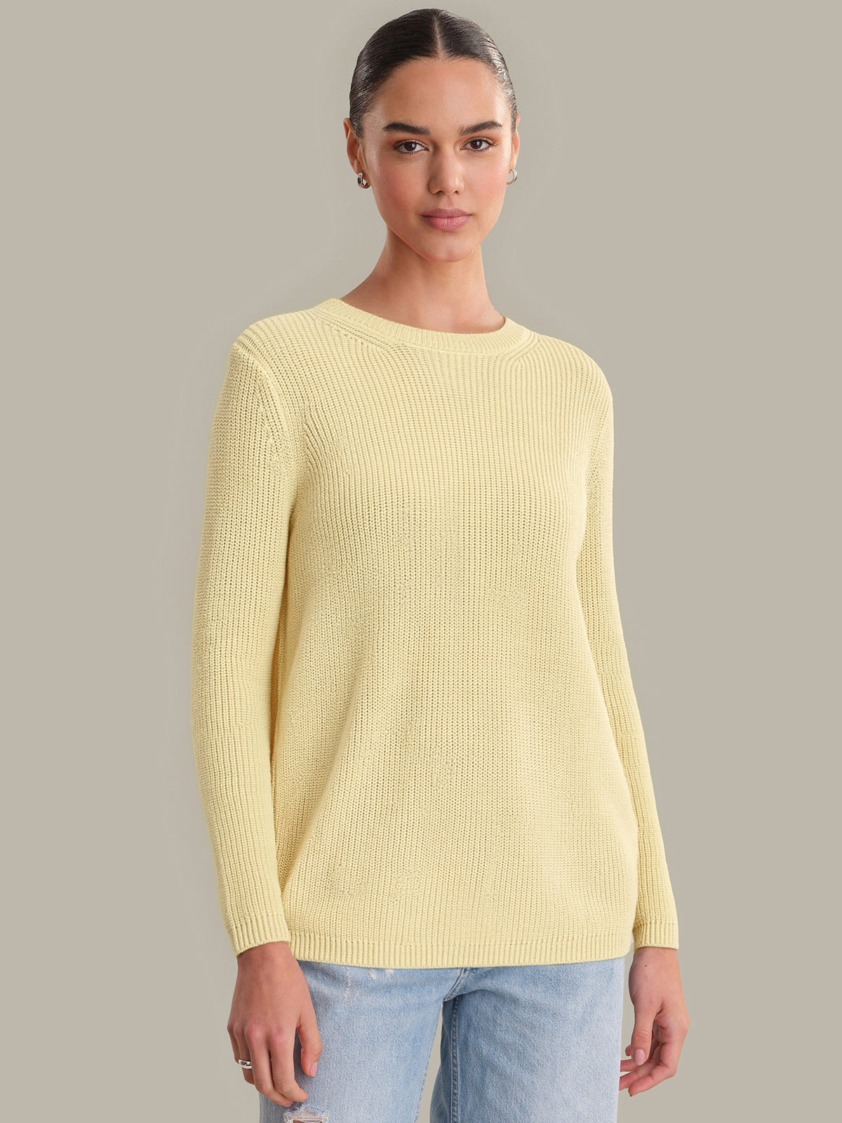 Woman wearing a yellow sweater against a plain background