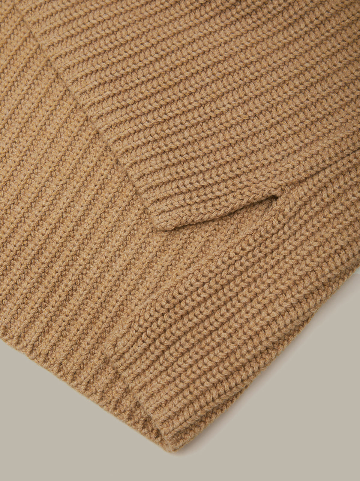 Close-up of a brown knitted fabric with a pocket on a light gray background