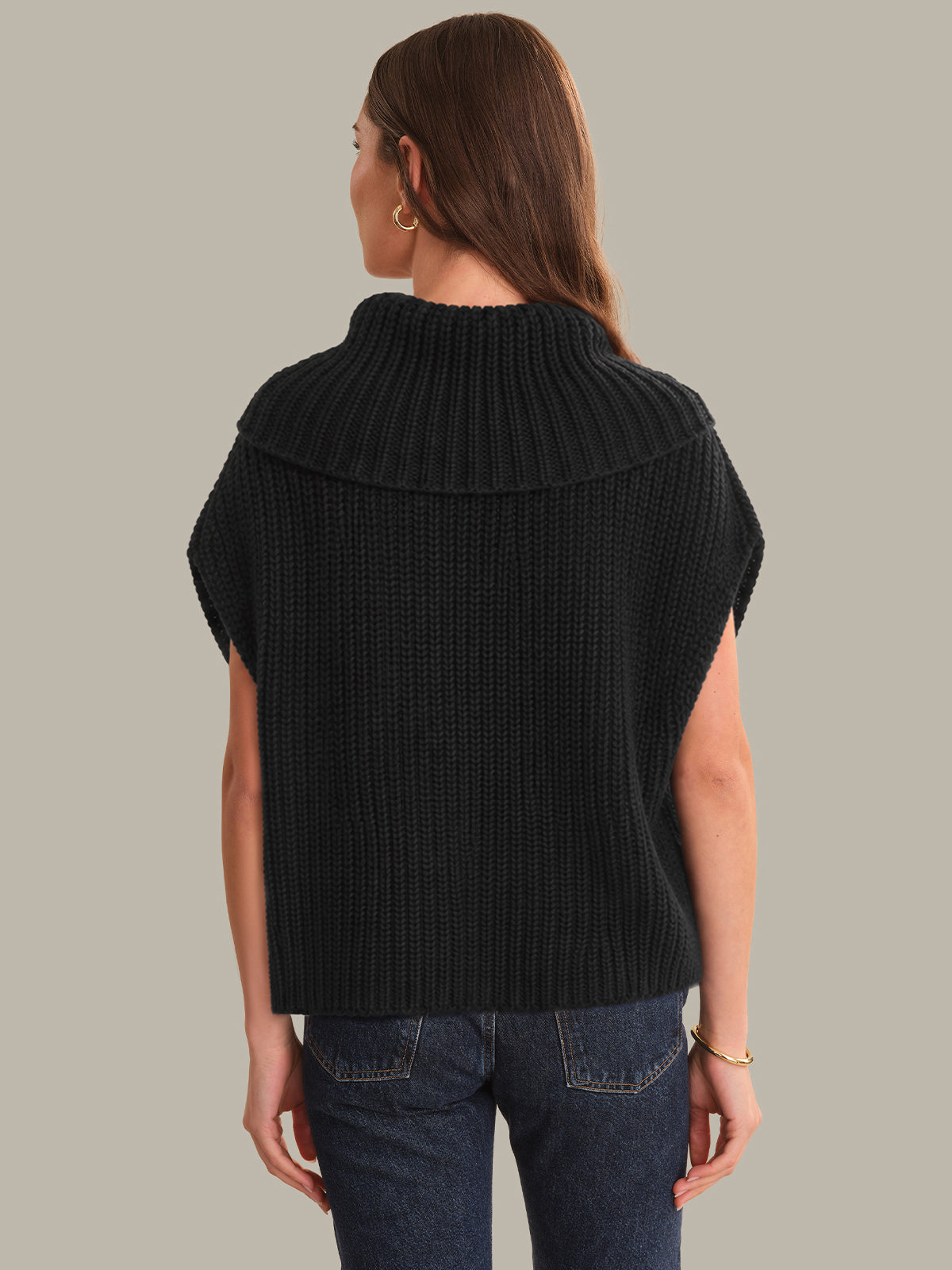 Person wearing a black ribbed knit vest on a gray background