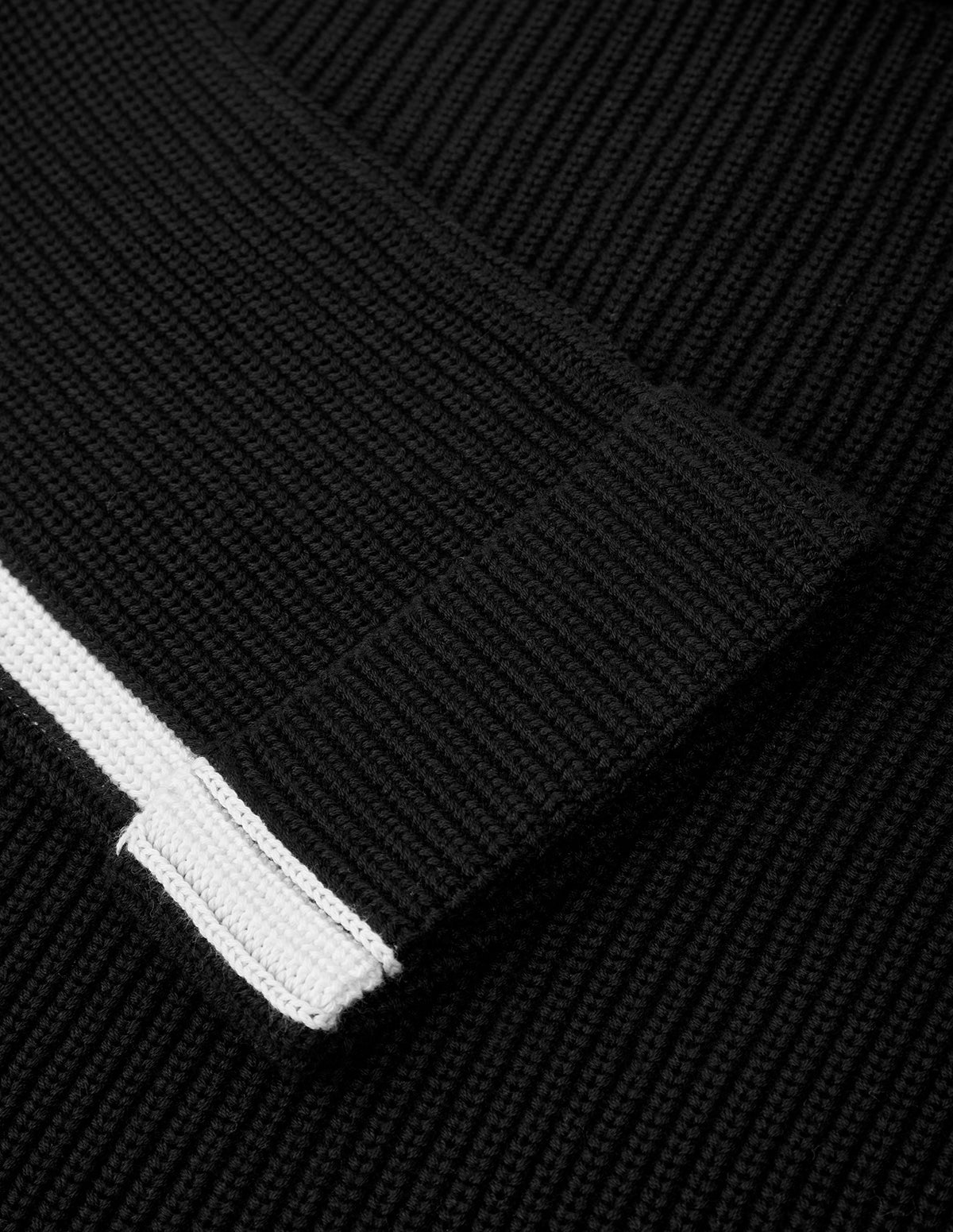 Close-up of a black textured fabric with a white zipper
