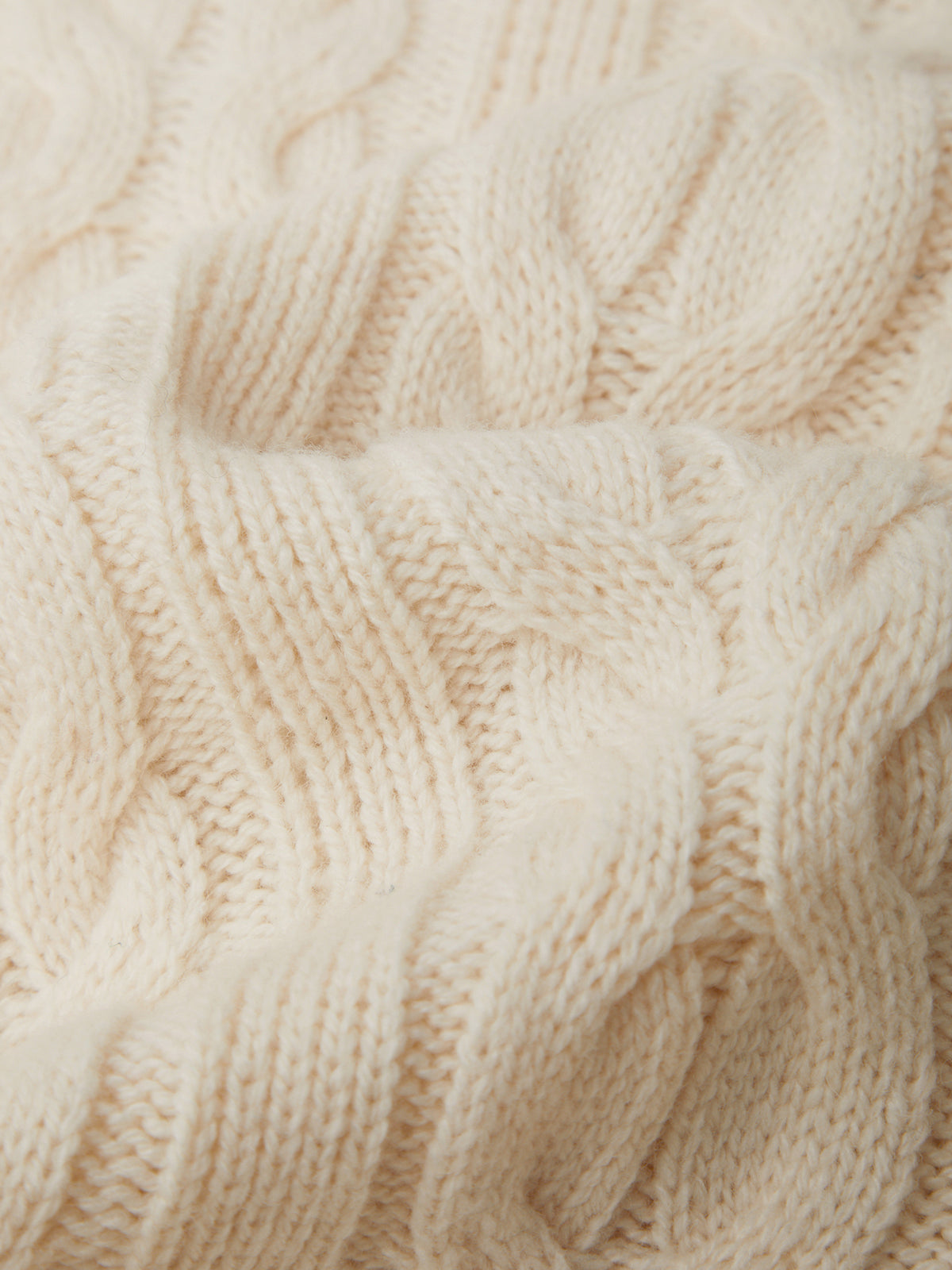 Close-up of beige knitted fabric with a textured pattern