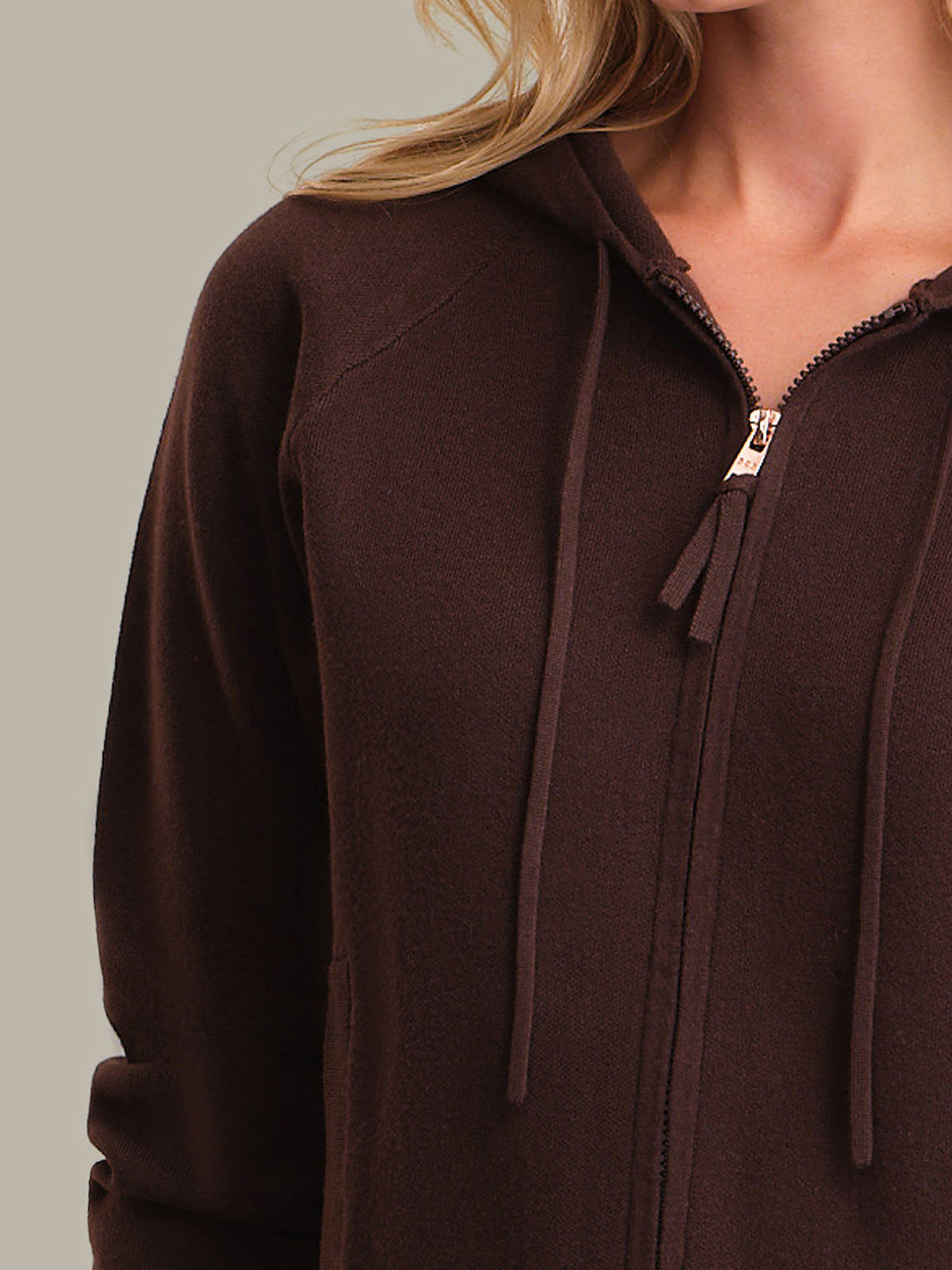 Brown zip-up hoodie worn by a person on a neutral background