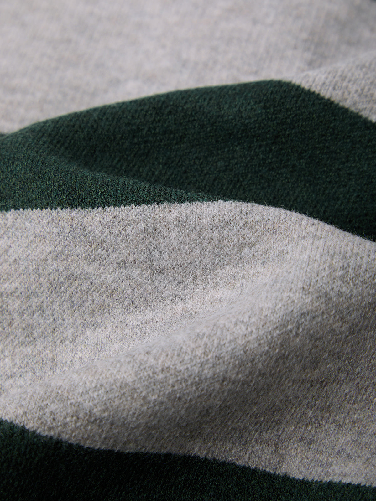 Close-up of a fabric with green, gray, and black stripes.