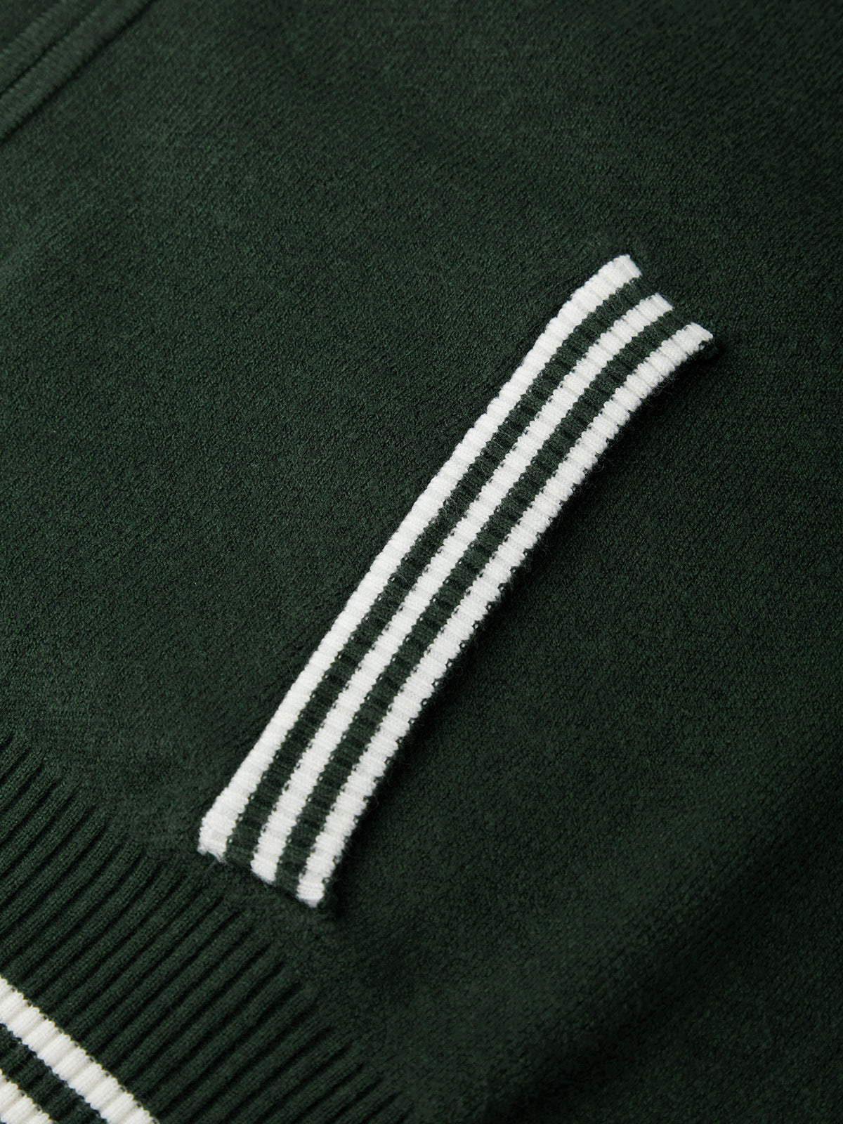 Close-up of a dark green sweater jacket with white stripes on the sleeve.