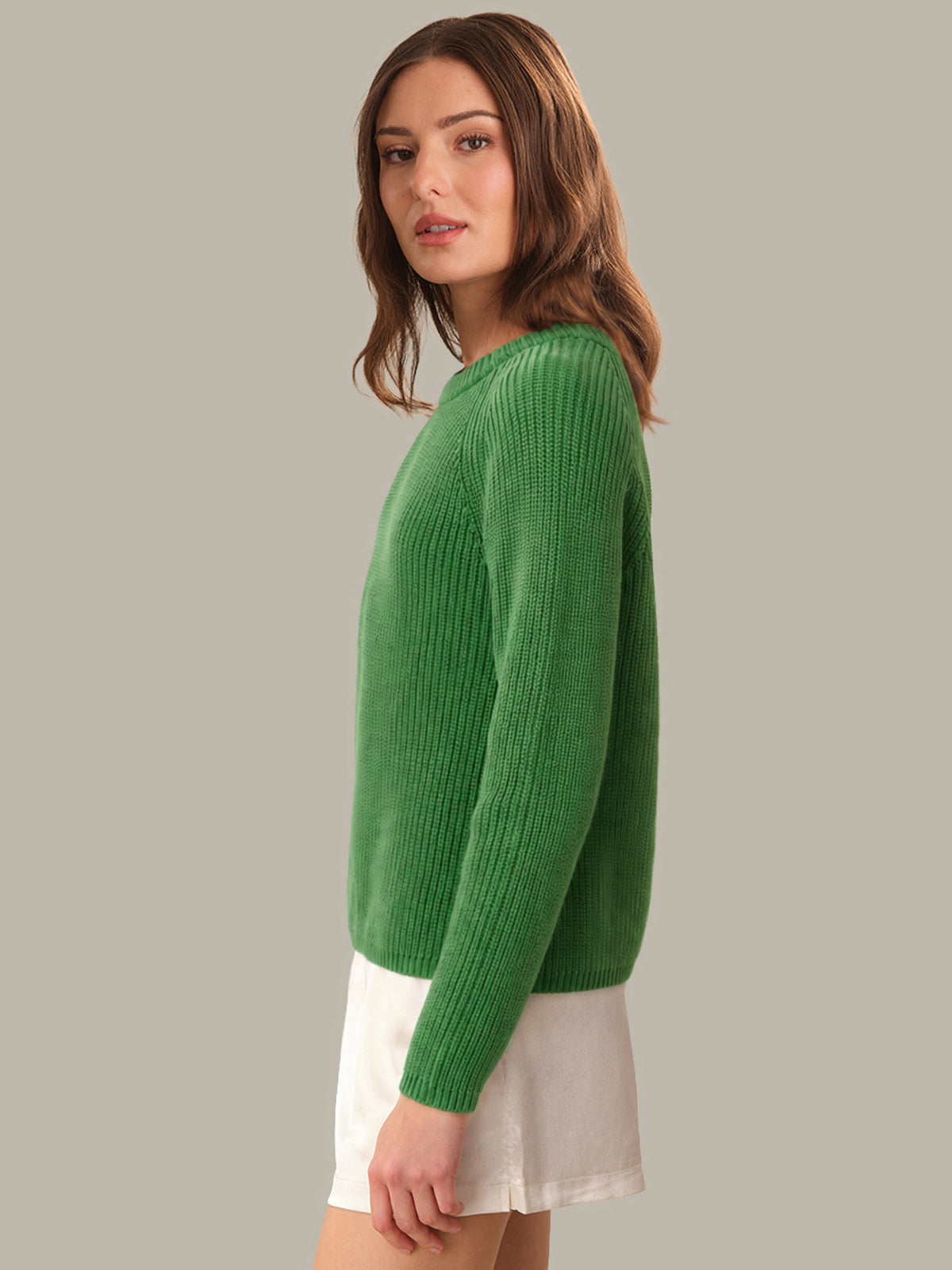 Woman wearing a green sweater against a gray background